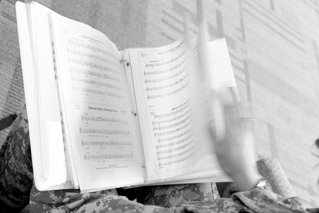 U.S. Army Spc. Anna Leverenz, Training and Doctrine Command band French horn player, searches through her music sheets in the break room at Fort Eustis, Va., Feb. 27, 2013. On an average day, the band members rehearse for upcoming concerts and perform their day-to-day duties, such as supply technician and public affairs specialist. (U.S. Air Force photo by Staff Sgt. Ashley Hawkins/Released) 