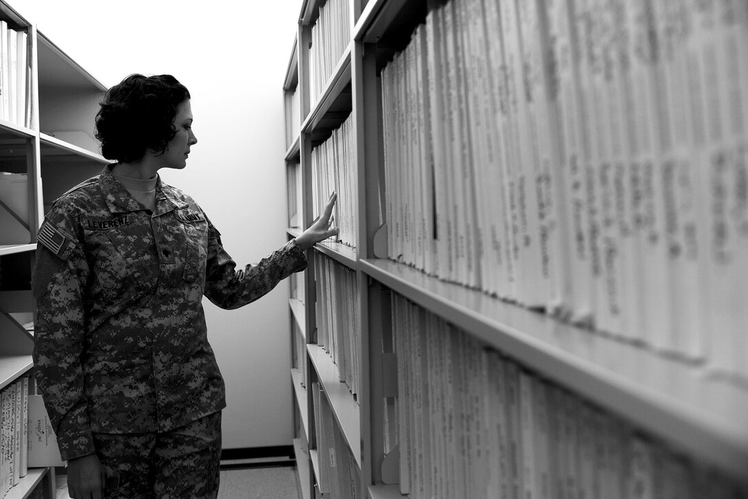 U.S. Army Spc. Anna Leverenz, a French horn player assigned to the U.S. Army Training and Doctrine Command band, searches through the unit’s music library at Fort Eustis, Va., Feb. 27, 2013. The library holds thousands of sheet music with categories ranging from concert pieces to specific instrument sections such as the brass section. (U.S. Air Force photo by Staff Sgt. Ashley Hawkins/Released) 