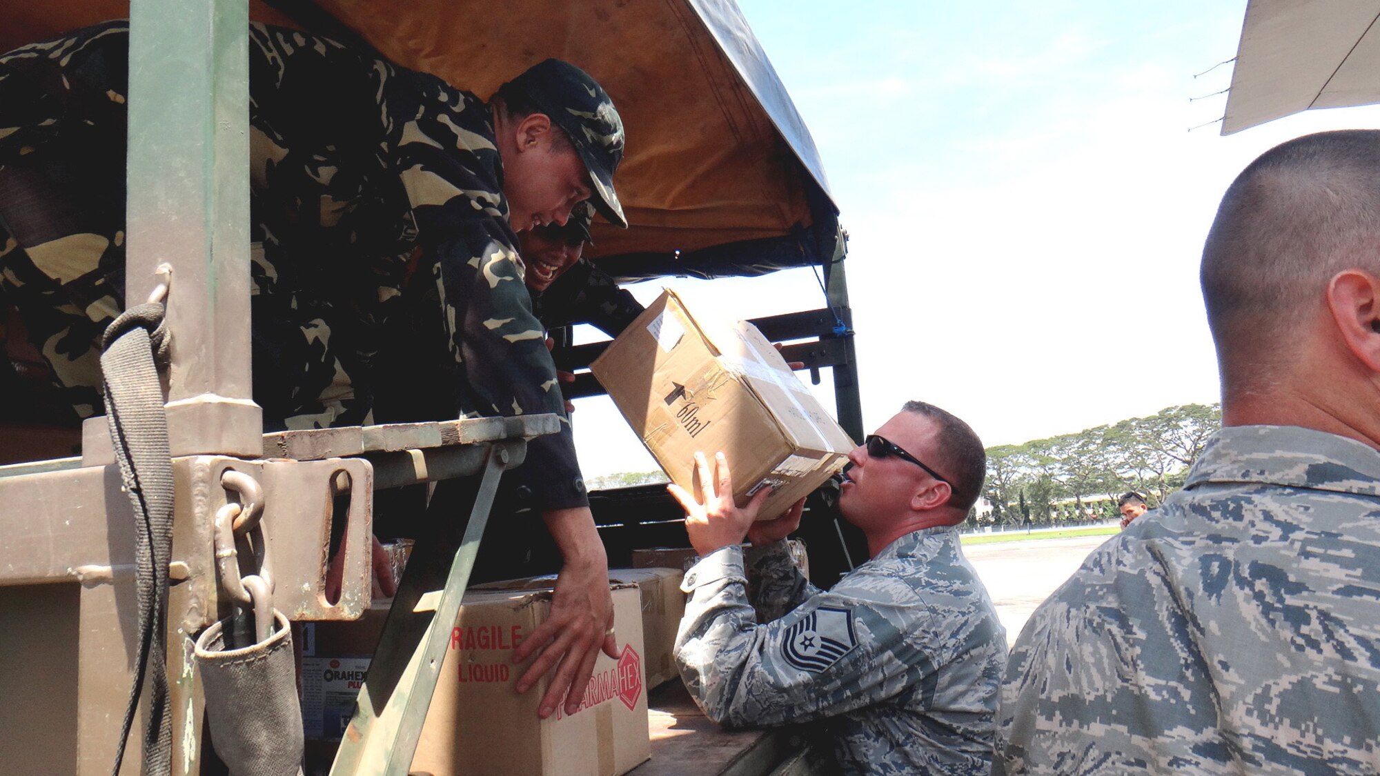 U.S. Air Force Master Sgt. Martin Grant (middle) passes a box of medical supplies to members of the Armed Forces of the Philippines at the airport in Dumaguete City, Philippines, March 1, 2013. An AFP C-130 delivered the medical supplies, making it the first time any host nation provided airlift assistance since Pacific Angel began in 2007. Grant is the NCO in charge of structures for the 36th Civil Engineer Squadron at Andersen Air Force Base, Guam, and is from Modesto, Calif. Approximately 220 U.S. service members along with the U.S. Air Force's F-22 Raptor, C-17 Globemaster III, F-16 Fighting Falcon, B-52 Stratofortress, and KC-135 Stratotanker are supporting the Australian International Airshow 2013, which allows a unique opportunity for the United States to showcase its aviation prowess and strengthen military-to-military ties with our Pacific allies and partners. (U.S. Air Force photo/2nd Lt. Son Lee)  