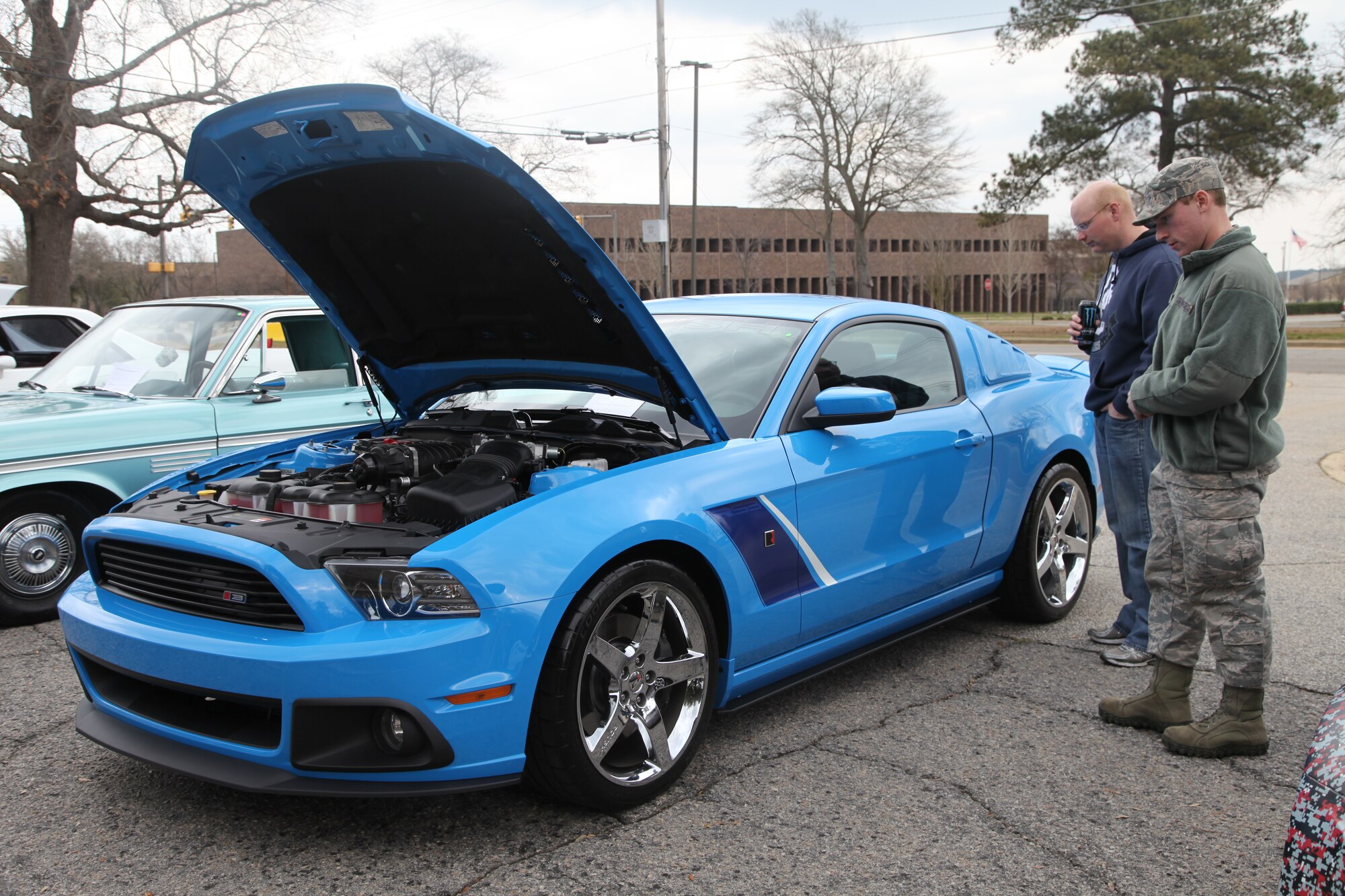 Shaw community members admire the design and model of a displayed Ford Mustang, Shaw Air Force Base, S.C., March 2, 2013. The event had about 50 vehicles on display that ranged from old classics to newer models. (Courtesy photo by Derrick Rhems/ Released)