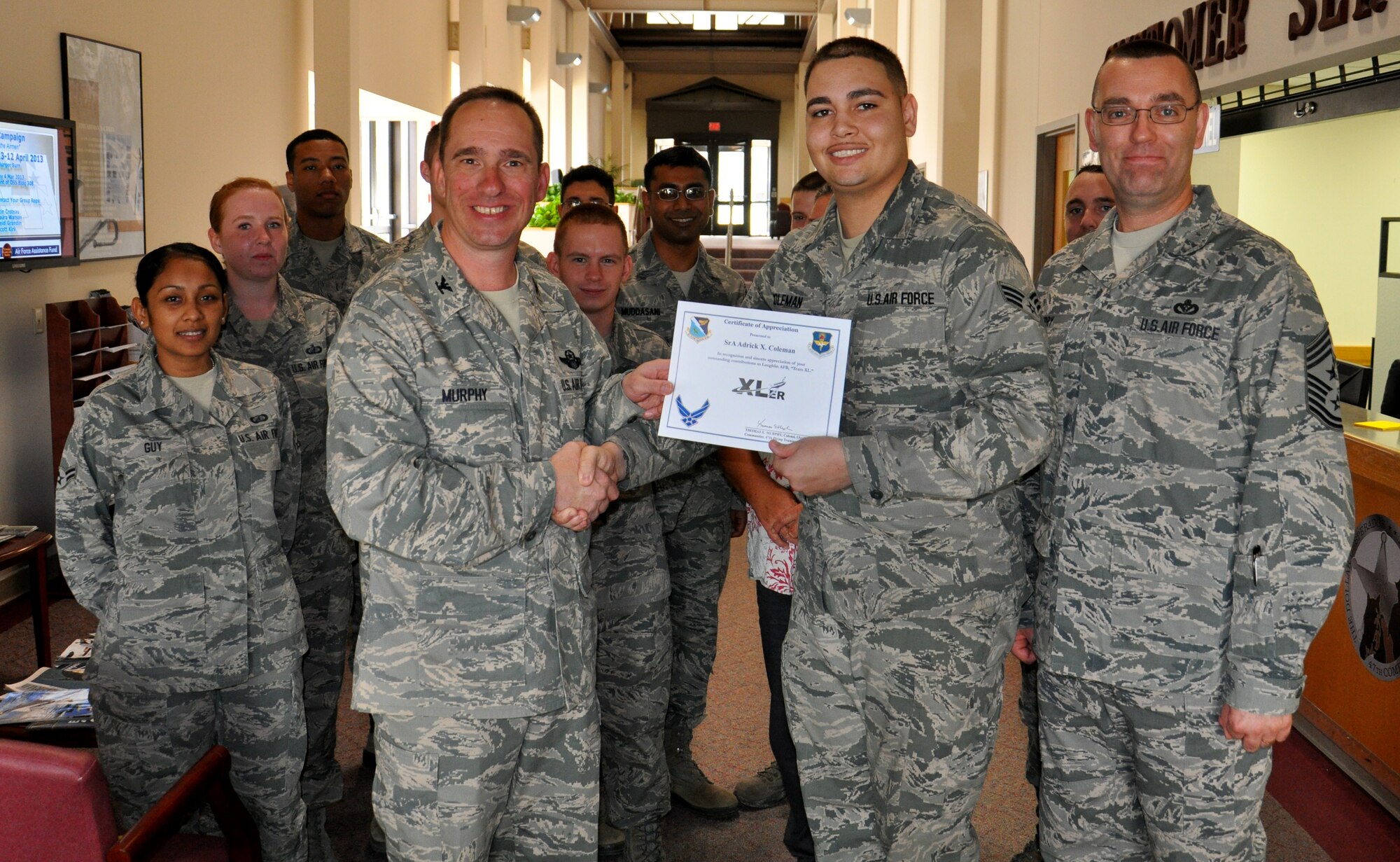 Senior Airman Adrick Coleman, 47th Comptroller Squadron lead financial services technician, poses with Col. Tom Murphy, 47th Flying Training Wing commander and Chief Master Sgt. Garry Berry, 47th FTW command chief, after being presented the XLer of the week award at Laughlin Air Force Base, Texas, Feb. 20, 2013. The XLer is a weekly award chosen by wing leadership and given to those who consistently make outstanding contributions to Laughlin and their unit. (U.S. Air Force photo/2nd Lt. Evan Ross)