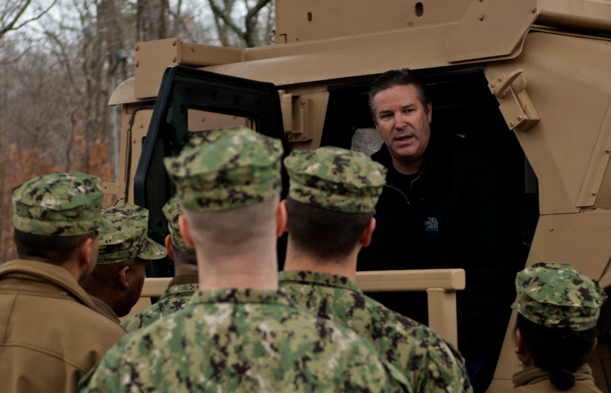 Anthony Harris, Army Support Activity Simulation Branch training support assistant, describes the importance of the Humvee Egress Assistance Trainer, or HEAT, to members of a U.S. Navy Expeditionary Combat Camera unit. The HEAT device trains Service members on the effects of a rollover and allows them conduct drills that will provide the skill and ability to react properly during emergency egress situations. (U.S. Air Force Photo by Airman 1st Class R. Alex Durbin/Released)
