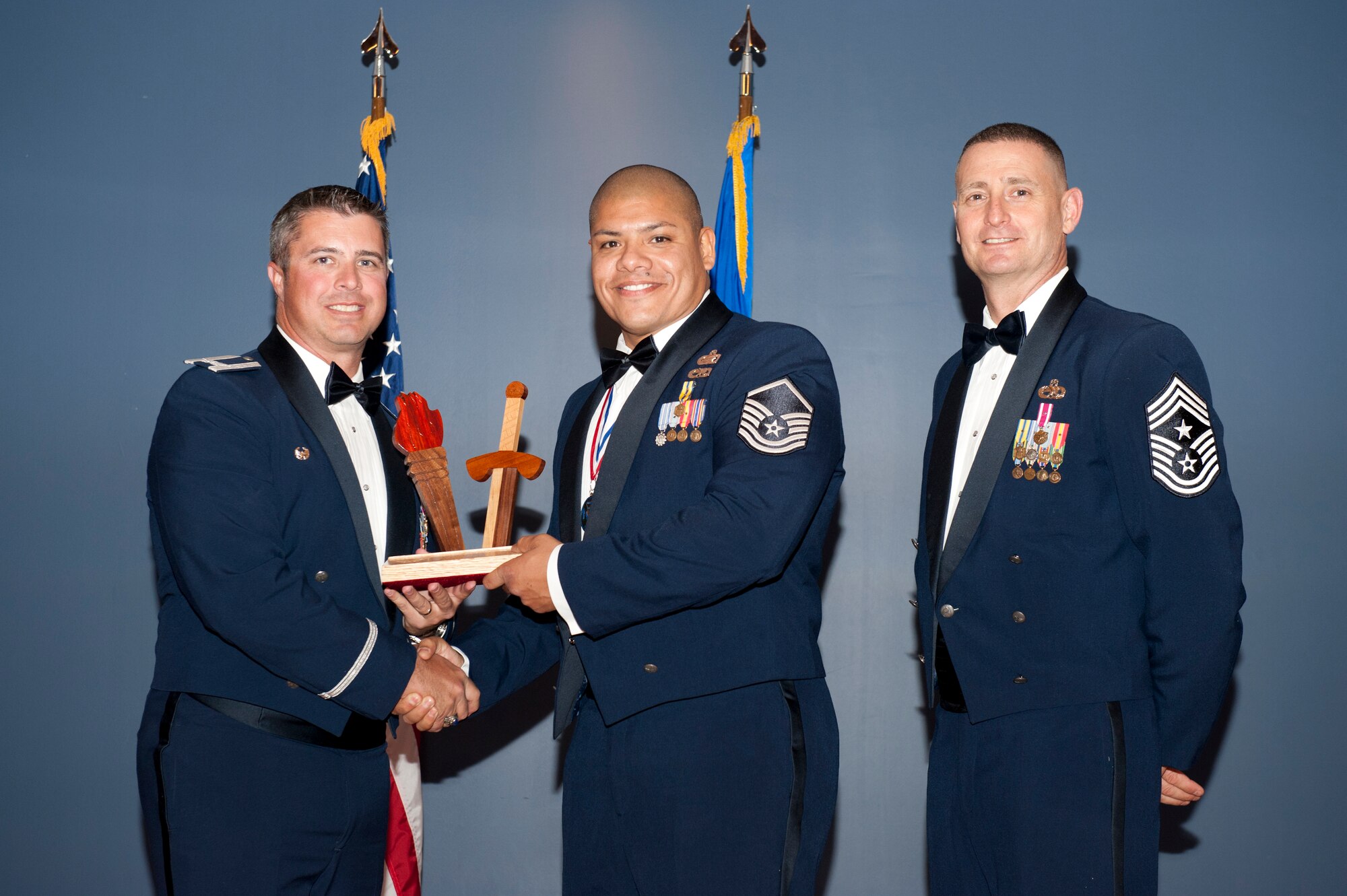 Master Sgt. Mike G. Mascorro, Personnel Support for Contingency Operations Training chief Det. 1, 823rd REDHORSE, accepts the Senior NCO of the Year award at the Annual Awards Banquet Feb. 20 from Col. David E. Graff, 325th Fighter Wing commander, and Chief Master Sgt. Ray DeVite, 325th FW command chief. (U.S. Air Force photo by Lisa Norman) 
