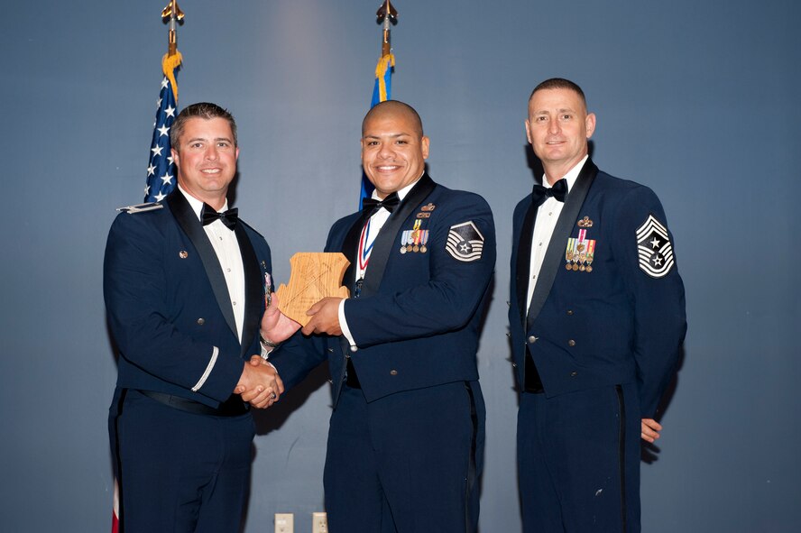 Master Sgt. Mike G. Mascorro, Personnel Support for Contingency Operations Training chief Det. 1, 823rd REDHORSE, accepts the Senior NCO of the Year award at the Annual Awards Banquet Feb. 20 from Col. David E. Graff, 325th Fighter Wing commander, and Chief Master Sgt. Ray DeVite, 325th FW command chief. (U.S. Air Force photo by Lisa Norman)
