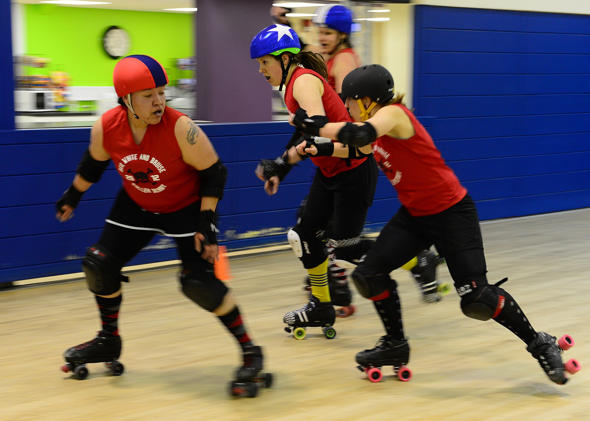 ROYAL AIR FORCE LAKENHEATH, England – Red, White and Bruises Rollers derby players Karri Hackney (center), attempts to score points by passing opposing team members Anita Rosa (left), 48th Munitions Squadron resource advisor, and Tarnna Hernandez (right), during a  practice scrimmage Feb. 21, 2013. RWBR is a private derby league at RAF Lakenheath and is open to women 18 years or older with a base access. (U.S. Air Force photo by Staff Sgt. Stephanie Mancha)