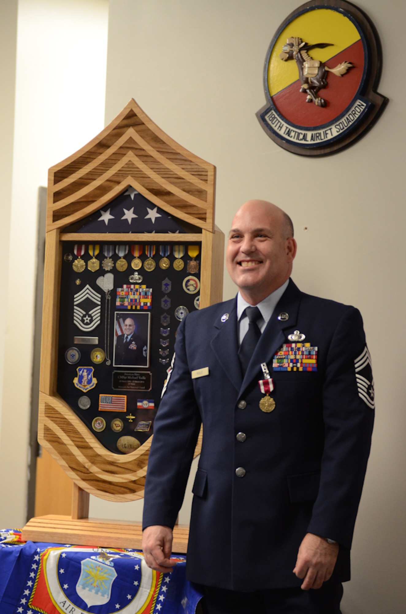 Chief Master Sgt. Mike Yuille, budget officer for the 139th Finance Office, stands next to his shadow box during his retirement ceremony March 5, 2013, at Rosecrans Air National Guard Base. (Missouri Air National Guard photo by Tech. Sgt. Michael Crane)