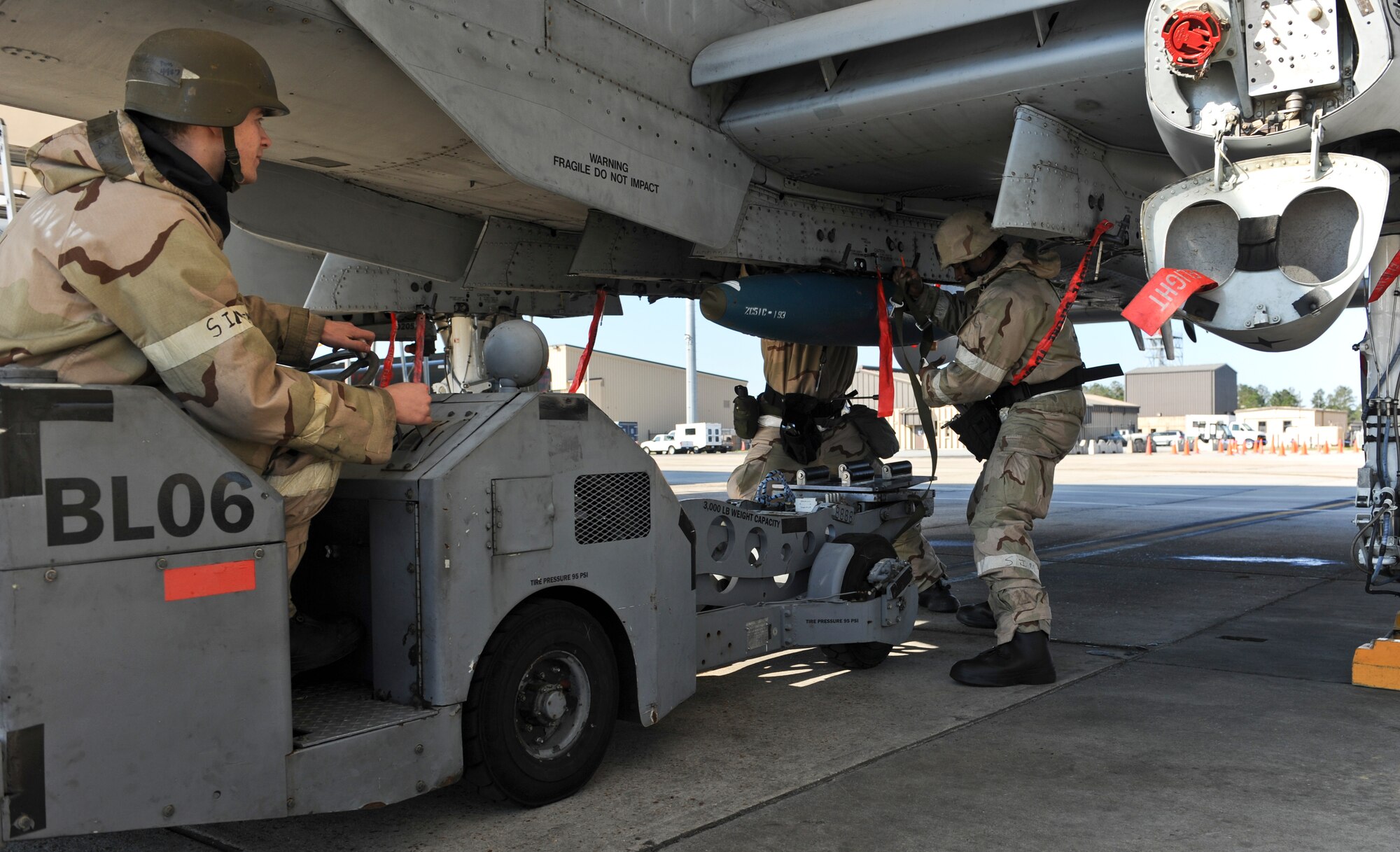 U.S. Air Force Staff Sgt. Harrison Ragin and Senior Airman Quinten Gregersen, 23d Maintenance Operations Squadron weapons load crew members, load a BDU-50 practice bomb on an A-10C Thunderbolt II during a phase II operational readiness exercise Feb. 28, 2013, at Moody Air Force Base, Ga. The Airmen made sure the bomb was properly secured. (U.S. Air Force photo by Airman Alexis Grotz/Released) 
