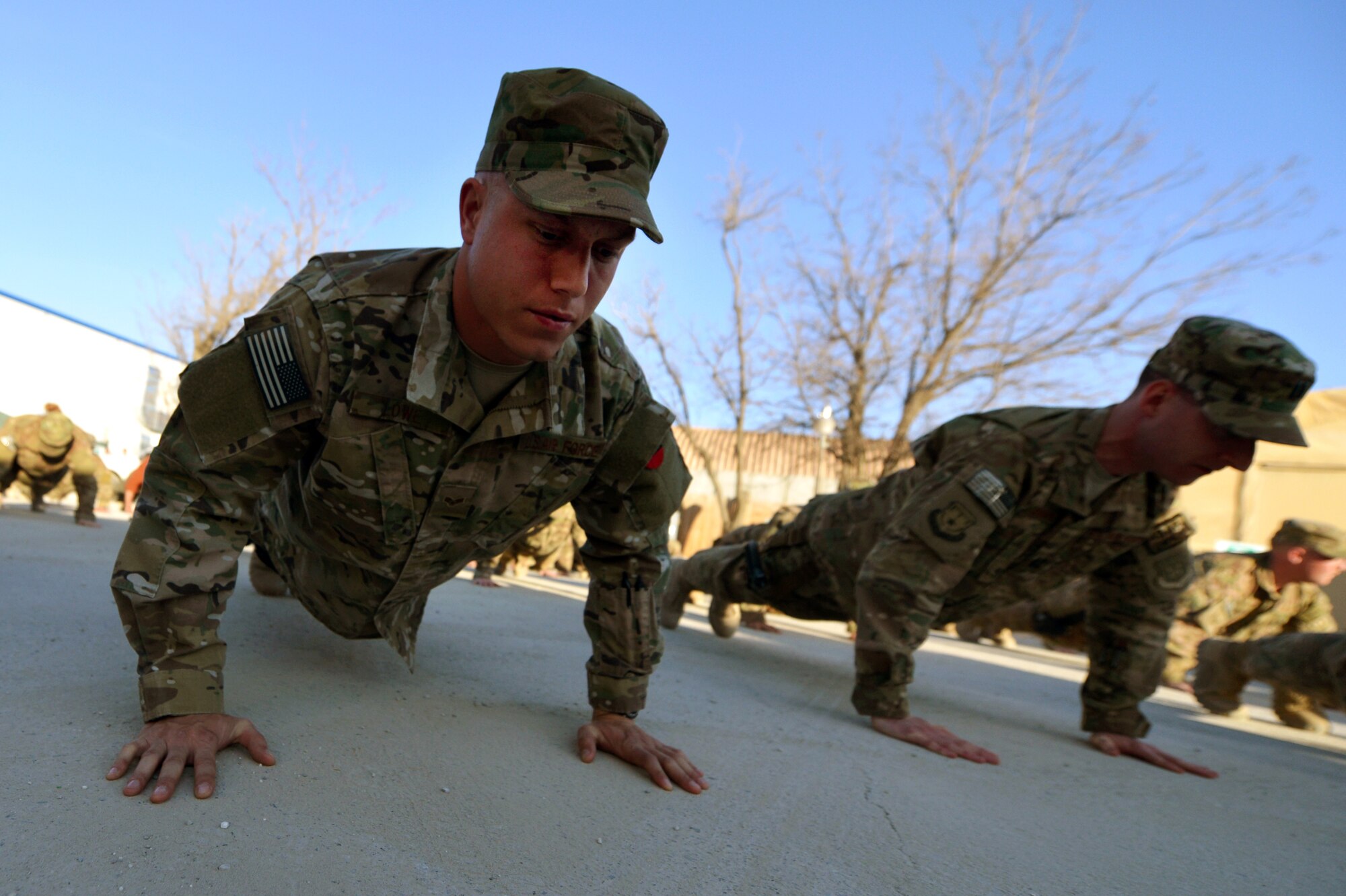 Senior Airman Jareth Jowe, 455th Expeditionary Aircraft Maintenance Squadron crew chief, and Capt. Wayne Barnum, 466th Air Expeditionary Group executive officer, honor Airmen who have fallen in support of Operation Enduring Freedom at Camp Cunningham on Bagram Airfield, Afghanistan, March 5, 2013.  Directly following the ceremony, the BAF members participated in group push-ups to honor teamwork  and fellow comrades. (U.S. Air Force photo/Senior Airman Chris Willis)                     