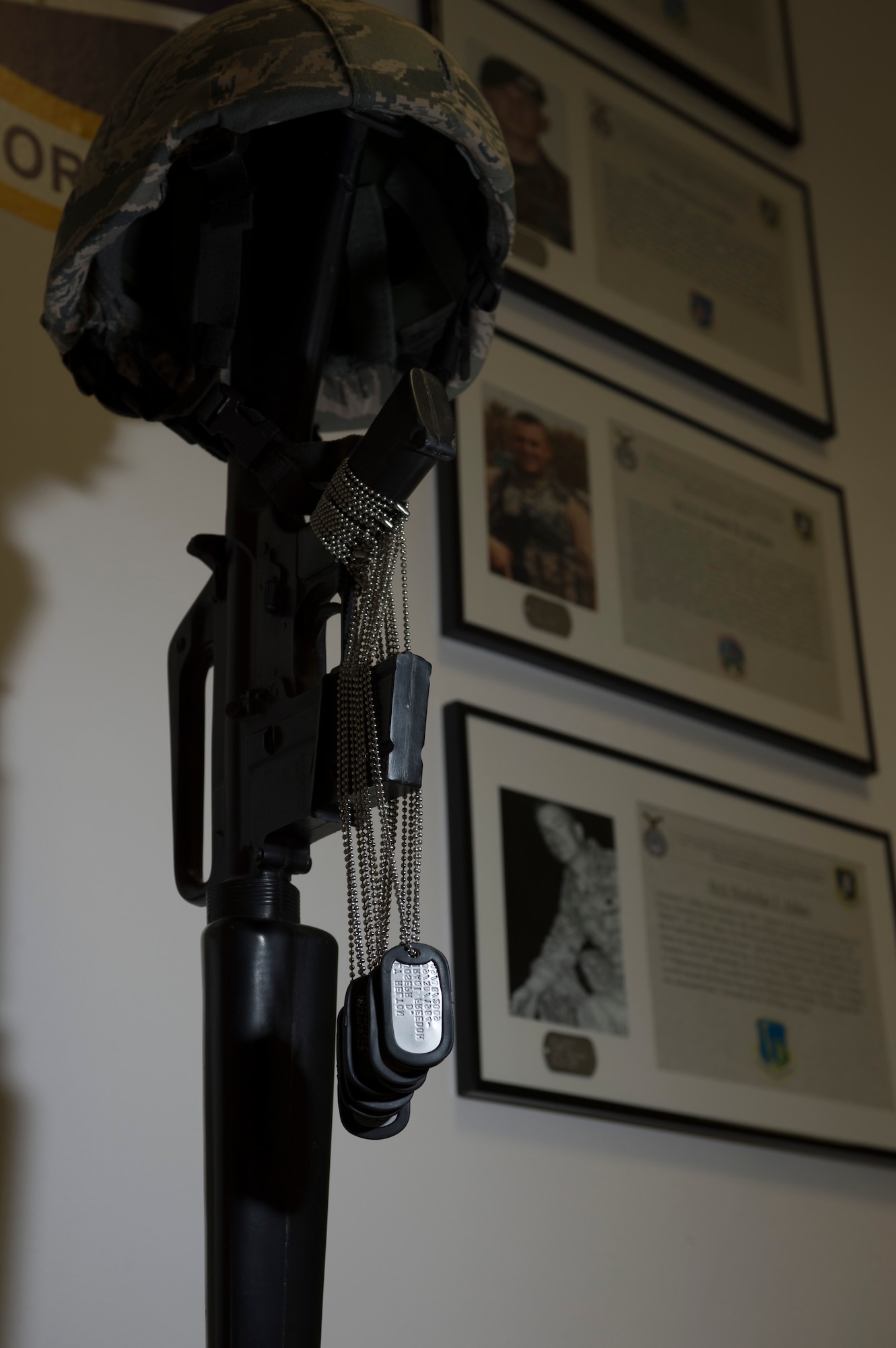 SPANDGDAHLEM AIR BASE, Germany – Dog-tags of nine fallen security forces members hang on an M-16 rifle as part of a Soldier’s cross March 1, 2013. This Soldier’s cross is a part of a memorial displayed at the 52nd Security Forces Squadron. The memorial commemorates nine fallen security forces Defenders who lost their lives serving their country after 9/11. (U.S. Air Force photo by Senior Airman Natasha Stannard/Released)