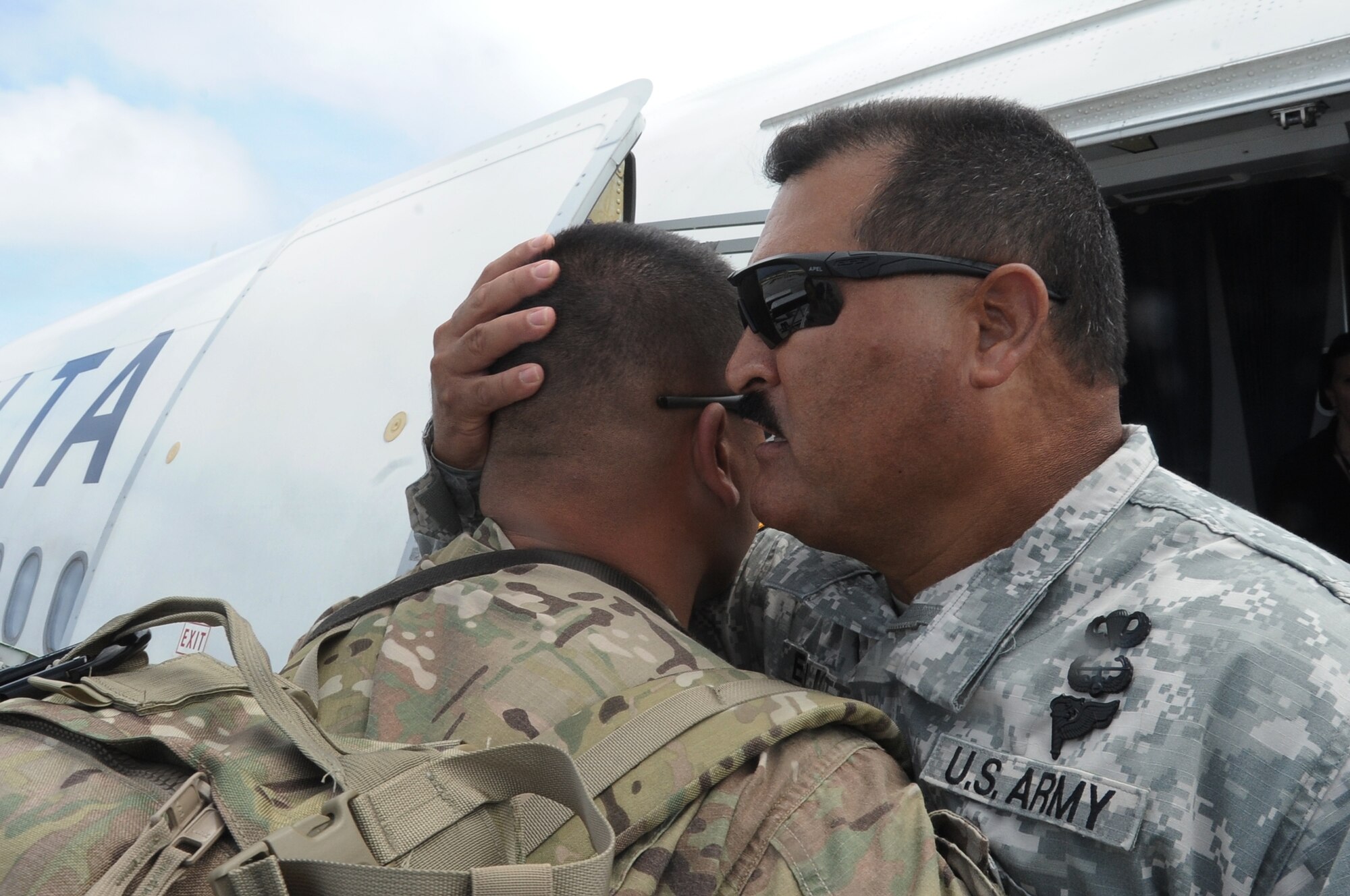 Army Command Sgt. Maj. Daniel Elliot, 1st Battalion, 294th Infantry Regiment, gives words of encouragement to his son as he departs Andersen Air Force Base, Guam, for a deployment to Afghanistan March 2, 2013.  The 36th Logistics Readiness Squadron served as the lead organization in executing the logistical portion of deploying about 600 Soldiers. (U.S. Air Force photo by Airman 1st Class Adarius Petty/Released)