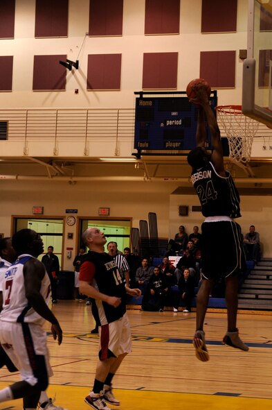 Maurice Roberson, 8th Civil Engineer Squadron, dunks the ball during the intramural championship game at Kunsan Air Base, Republic of Korea, March 1, 2013. Roberson and Elvis Shaw, 8th CES, both scored 14 points each to help bring their team to victory over the 8th Force Support Squadron. (U.S. Air Force photo by Senior Airman Marcus Morris/Released)