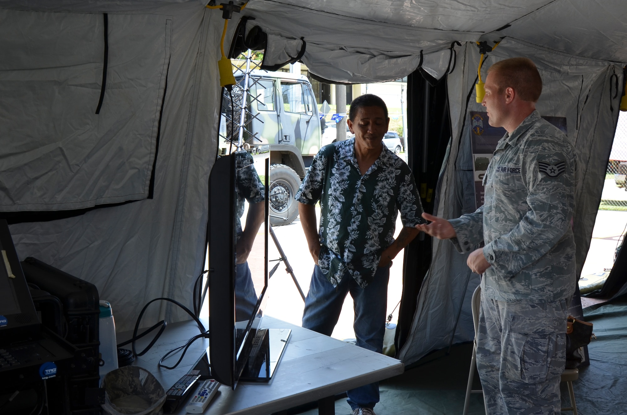 Staff Sgt. Scott Irwin, 644th Combat Communications Squadron cyber systems operations technician, explains to a Discovery Day participant how the 644th CBCS receives transmission in rural areas as part of the Sister Village program in Umatac, Guam, March 2, 2013. The Sister Village program allows a squadron from Andersen to partner with a local village and develop relationships with local community members. (U.S. Air Force photo by Staff Sgt. Alexandre Montes/Released)