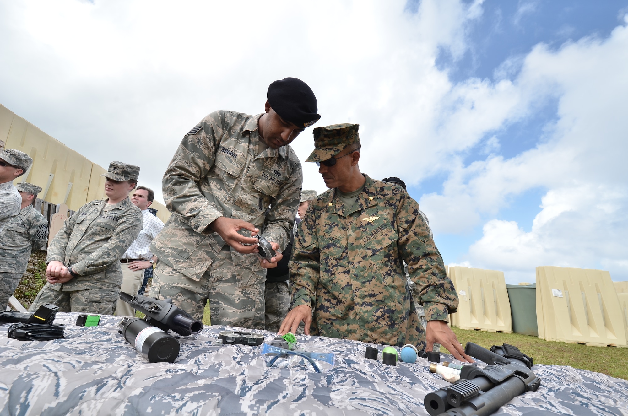(Left) Staff Sgt. Jason Brown, 736th Security Forces Squadron commander, talks about new rubber bullets used for training to (right) U.S. Marine Corps Maj. Darren Alvarez, Joint Guam Program Office, at the Pacific Regional Training Center on Northwest Field, Guam, Feb. 27, 2013. The leaders toured base structures and developments to gain insight on successes and challenges within Joint Region Marianas and the PRTC. (U.S. Air Force photo Staff Sgt. Alexandre Montes/Released)