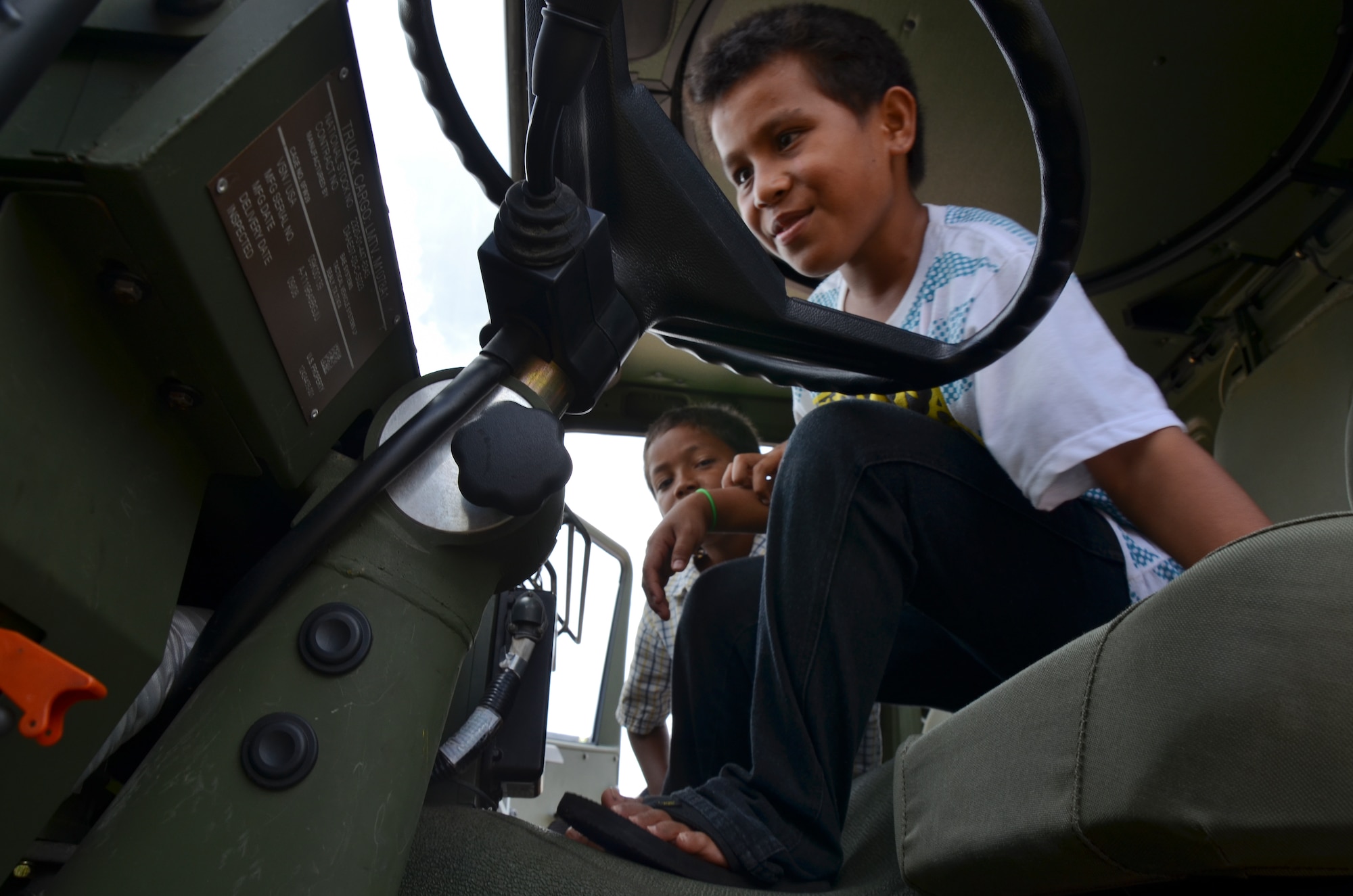Jeffer Lorenzo and Zaine Baker, Umatac residents, take a tour of a 644th Combat Communications Squadron vehicle during Discovery Day as part of the Sister Village program in Umatac, Guam, March 2, 2013. The Sister Village program allows a squadron from Andersen to partner with a local village and develop relationships with local community members. (U.S. Air Force photo by Staff Sgt. Veronica McMahon/Released)