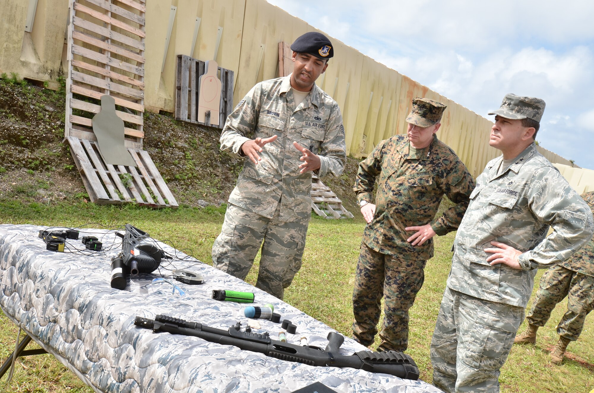 (Left) Staff Sgt. Jason Brown, 736th Security Forces Squadron Commando Warrior instructor, describes the different types of armament Airmen train with at the Pacific Regional Training Center to (center) U.S. Marine Corps Maj. Gen. James Kessler, commander, Marine Corps Installations Command, and (right) Maj. Gen. Timothy Byers, Air Force Civil Engineer, Headquarters U.S. Air Force, on Northwest Field, Guam, Feb. 27, 2013. The leaders toured base structures and developments to gain insight on successes and challenges within Joint Region Marianas. (U.S. Air Force photo Staff Sgt. Alexandre Montes/Released)