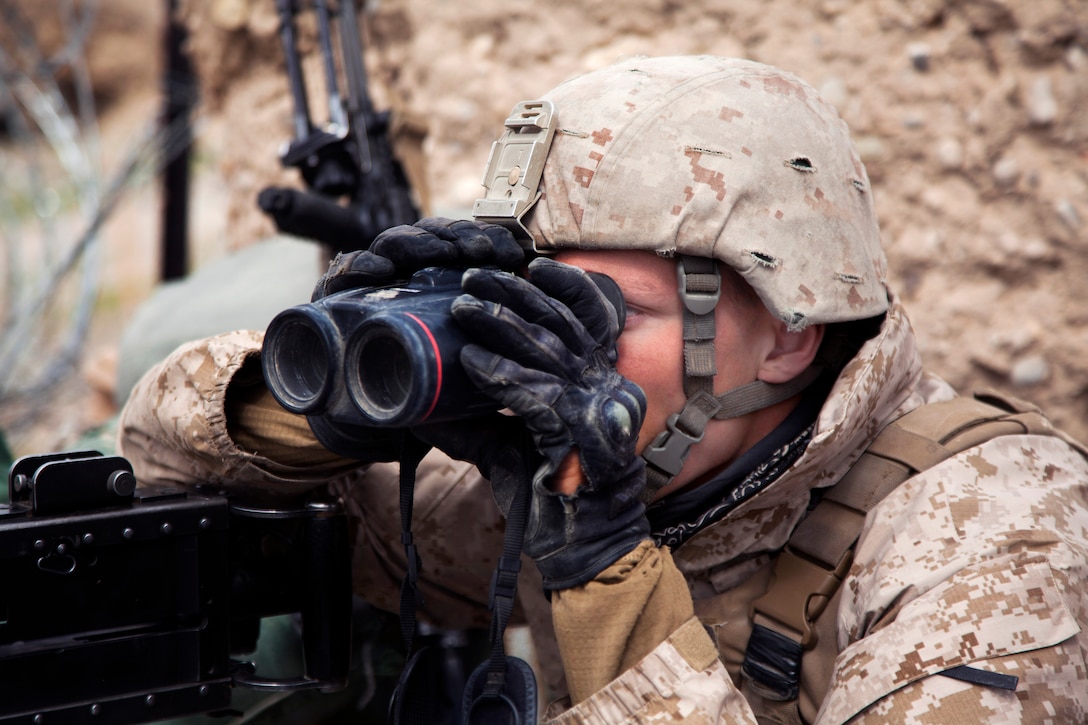 U.S. Marine Corps Lance Cpl. Kody King uses binoculars to scan for ...