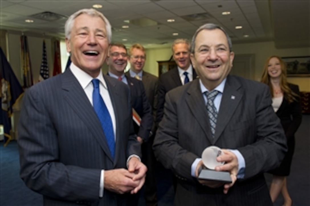 Secretary of Defense Chuck Hagel, left, shares a laugh with Israeli Minister of Defense Ehud Barak after presenting him with a crystal globe at the conclusion of their meeting in the Pentagon on March 5, 2013.  Hagel, Barak and members of their senior staff met to discuss national security items of interest to both nations.  