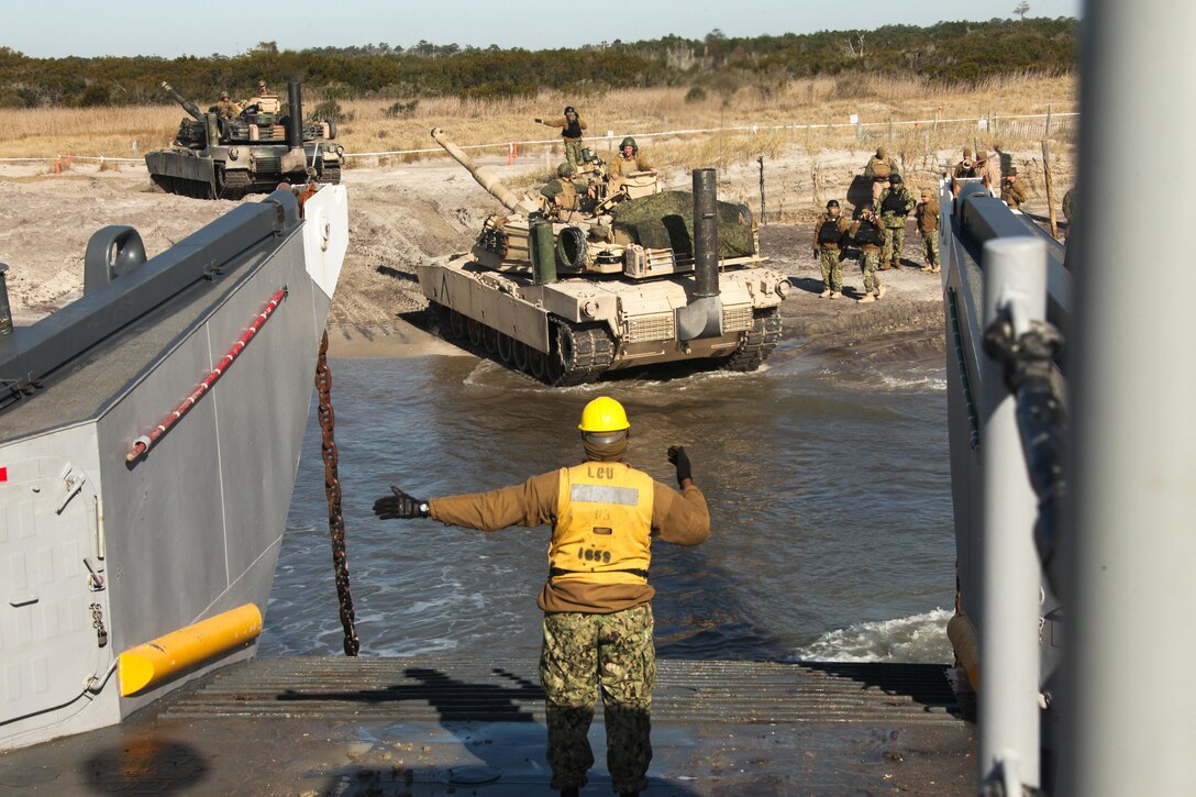 Marines with Alpha Company, 2nd Tank Battalion, 2nd Marine Division, load tanks into a Landing Craft Utility, at Onslow Beach, March 1, 2013. The Marines practiced loading and unloading tanks onto the LCU with the help of sailors with Naval Beach Party Team 3, Beach Master Unit 2 to keep up their skills as an amphibious force in readiness.