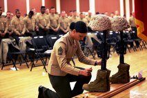 A Marine pays her respects to Cpl. Christopher M. Monahan Jr. and Lance Cpl. Dale W. Means, motor transportation operators with Combat Logistics Battalion 2, 2nd Marine Logistics Group, who were killed in Helmand province, Afghanistan, November 2012. The battalion hosted a memorial ceremony to allow the families and friends to join the unit in honoring the sacrifices of the two Marines. 