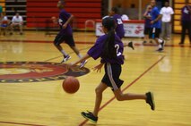 A student from Brewster Middle School dashes across the court during a Hoops-N-Dreams jamboree aboard Camp Lejeune, N.C., Feb. 22, 2013. Children of varying ages and skill levels played on four teams coached by volunteers from around the base during the event. 