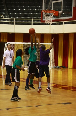 Participants in a Hoops-N-Dreams jamboree aboard Camp Lejeune, N.C., vie for position during a basketball game Feb. 22, 2013. The Hoops-N-Dreams program hosted the event to allow the children to engage in a friendly game of basketball officiated by volunteers from various units across the base. 