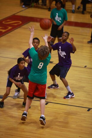 A participant in a Hoops-N-Dreams jamboree shoots during a basketball game aboard Camp Lejeune, N.C., Feb. 22, 2013. Four teams of students from Brewster Middle School, which caters to the children of servicemembers serving aboard the base, participated in the event. 
