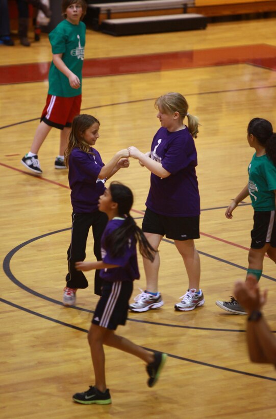 Two students from Brewster Middle School celebrate a scoring drive during a Hoops-N-Dreams jamboree aboard Camp Lejeune, N.C, Feb. 22, 2013. The event stressed teamwork and mutual respect between the participants as they put their teamwork to the test during the game. 