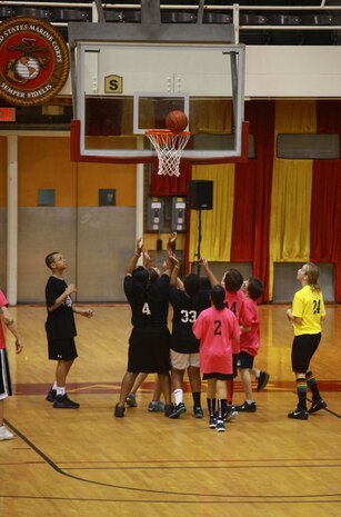 Student from Brewster Middle School wait for the rebound during a Hoops-N-Dreams jamboree aboard Camp Lejeune, N.C., Feb. 22, 2013. Volunteers from across the base helped coach four teams of students during the event, which allowed children of various ages and skill levels to participate in a friendly game of basketball. 