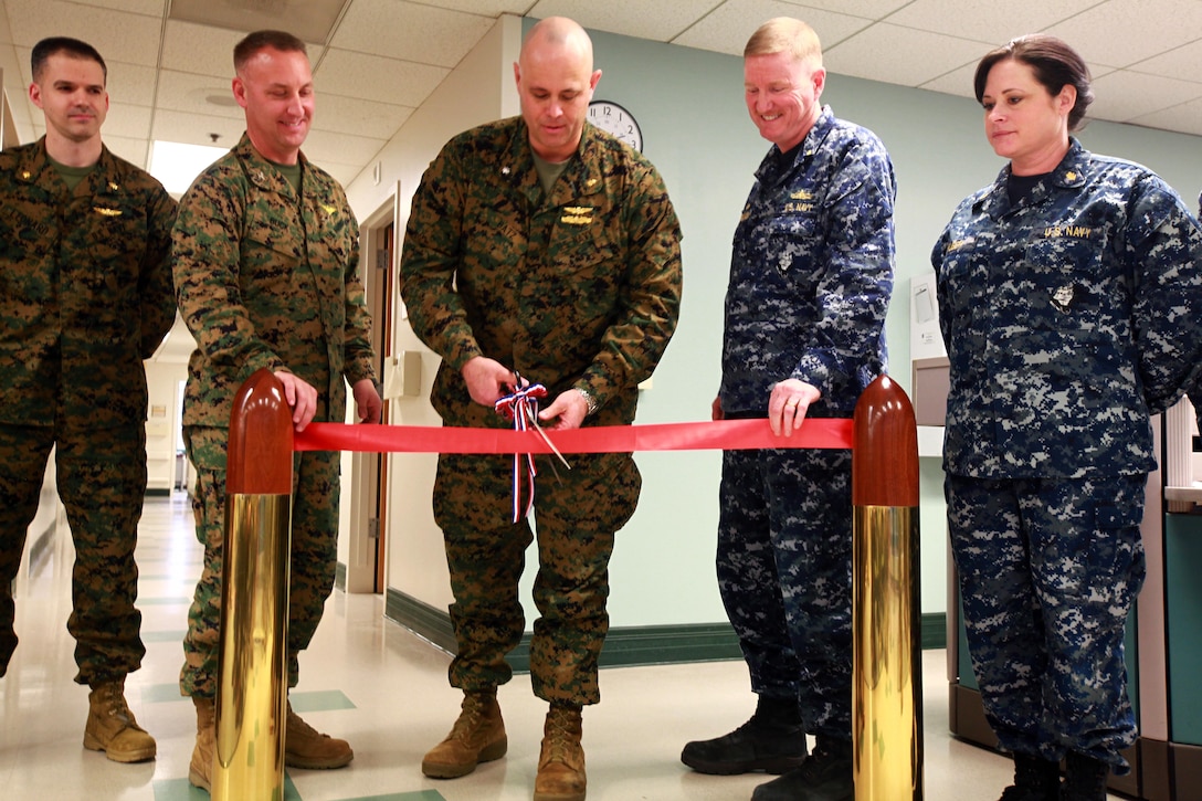From left to right, Lt. Cmdr. Sean P. Leonard, Warrior Wellness and Readiness Clinic senior medical officer; Col. Peter D. Buck, 2nd Marine Aircraft Wing chief of staff; Cmdr. Raymond Batz, 2nd MAW wing surgeon; Capt. John F. Ferguson, Naval Health Clinic Cherry Point commanding officer; and Lt. Cmdr. Linda A. Huber, Warrior Wellness and Readiness Clinic officer in charge, cut the ribbon during a ceremony at the new clinic announcing its official opening Feb. 28. The Naval Health Clinic and 2nd Marine Aircraft Wing have joined to transform medical care in garrison. The goals of the clinic includes improving medical readiness, increasing continuity of care through primary care managers, and fostering a team approach to health care to achieve a fully ready and mission-capable fighting force.
