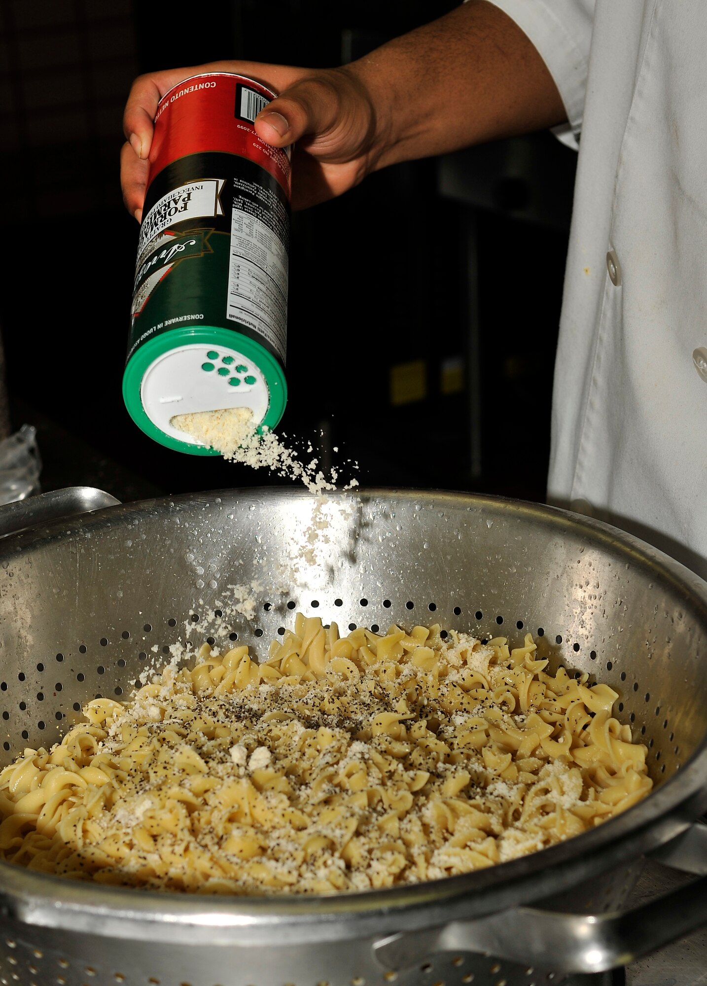 U.S. Air Force Airman 1st Class Sertaba Campbell, 354th Force Support Squadron chef, adds parmesan cheese to Jefferson noodles as part of the Go for Green program Feb. 26, 2013, Eielson Air Force Base, Alaska. Entrees labeled green are less than 300 calories, less than 10 g of fat and less than 480 mg of sodium. (U.S. Air Force photo/Racheal E. Watson)