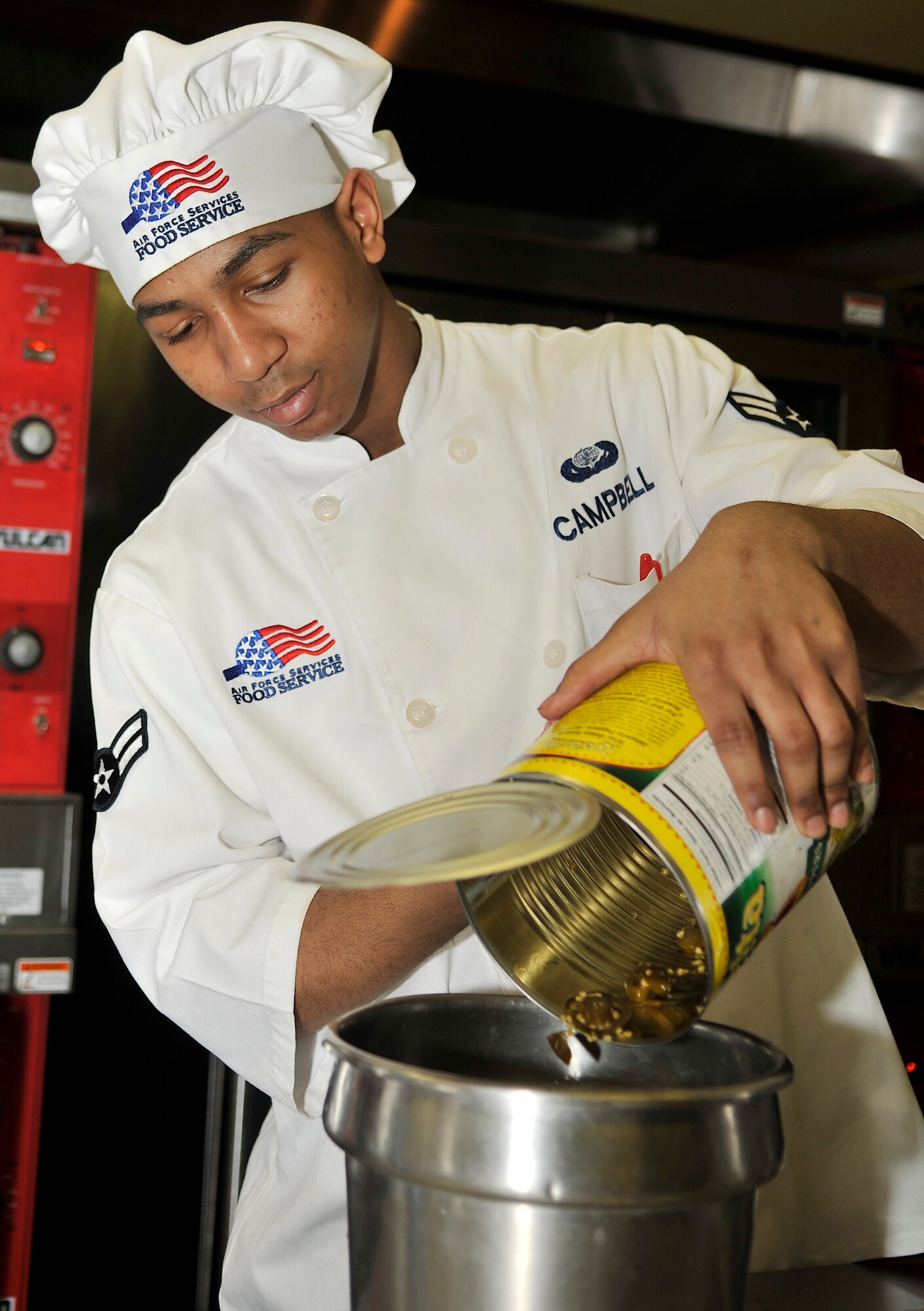 U.S. Air Force Airman 1st Class Sertaba Campbell, 354th Force Support Squadron chef, pours jalapenos into a food container as part of the Go for Green program Feb. 26, 2013, Eielson Air Force Base, Alaska. The Go for Green program uses a stop-light color labeling system to identify healthier food items. (U.S. Air Force photo/Racheal E. Watson)
