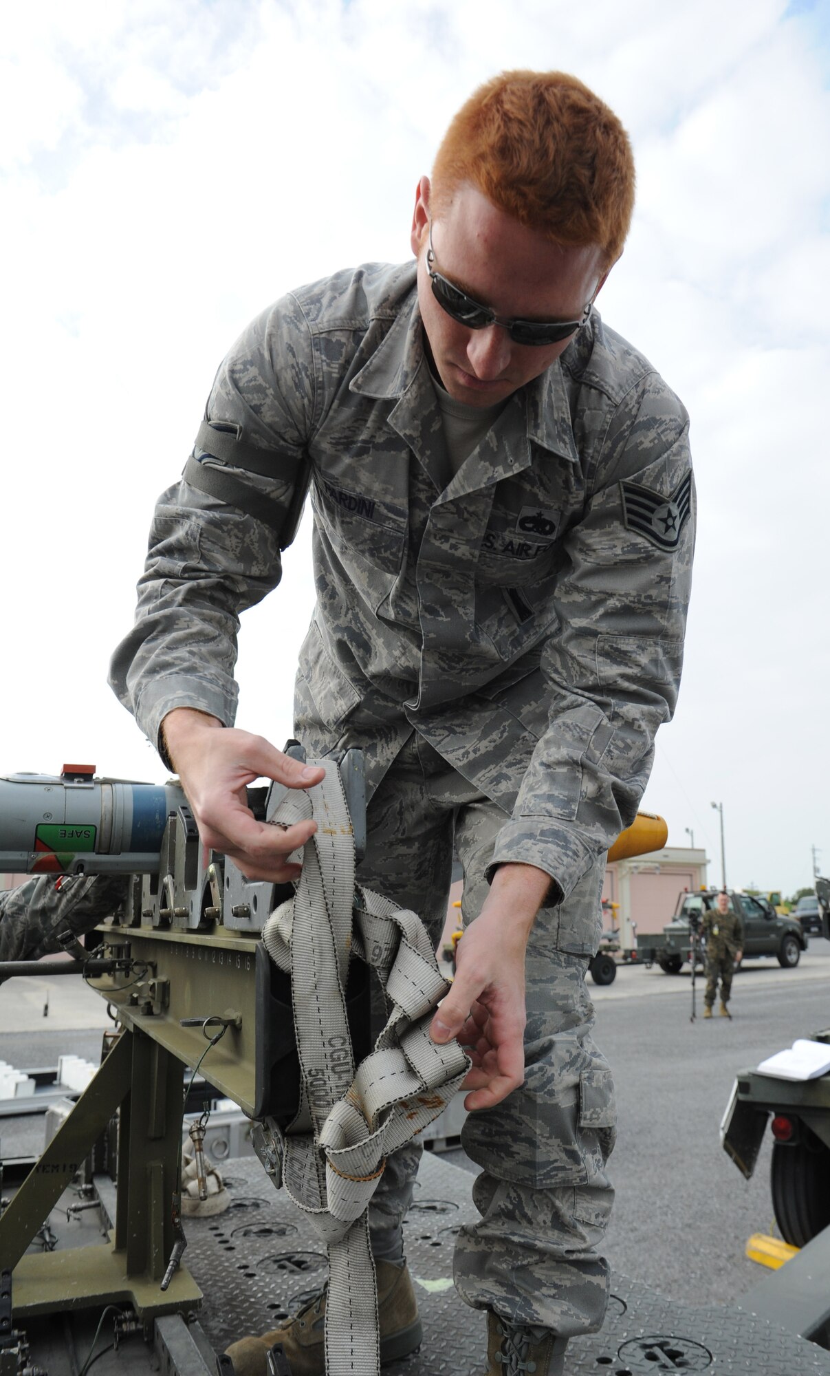 U.S. Air Force Staff Sgt. Anthoni Pardini, 18th Munitions Squadron precision guided missile crew chief, unties a belt to secure a dummy air-to-air 9X training missile during a combat ammunition production exercise on Kadena Air Base, Japan, March 5, 2013. The exercise is a Pacific Air Forces exercise held annually to test the munitions Airmen's ability to build ammunition for wartime aircraft. (U.S. Air Force photo/Airman 1st Class Malia Jenkins)