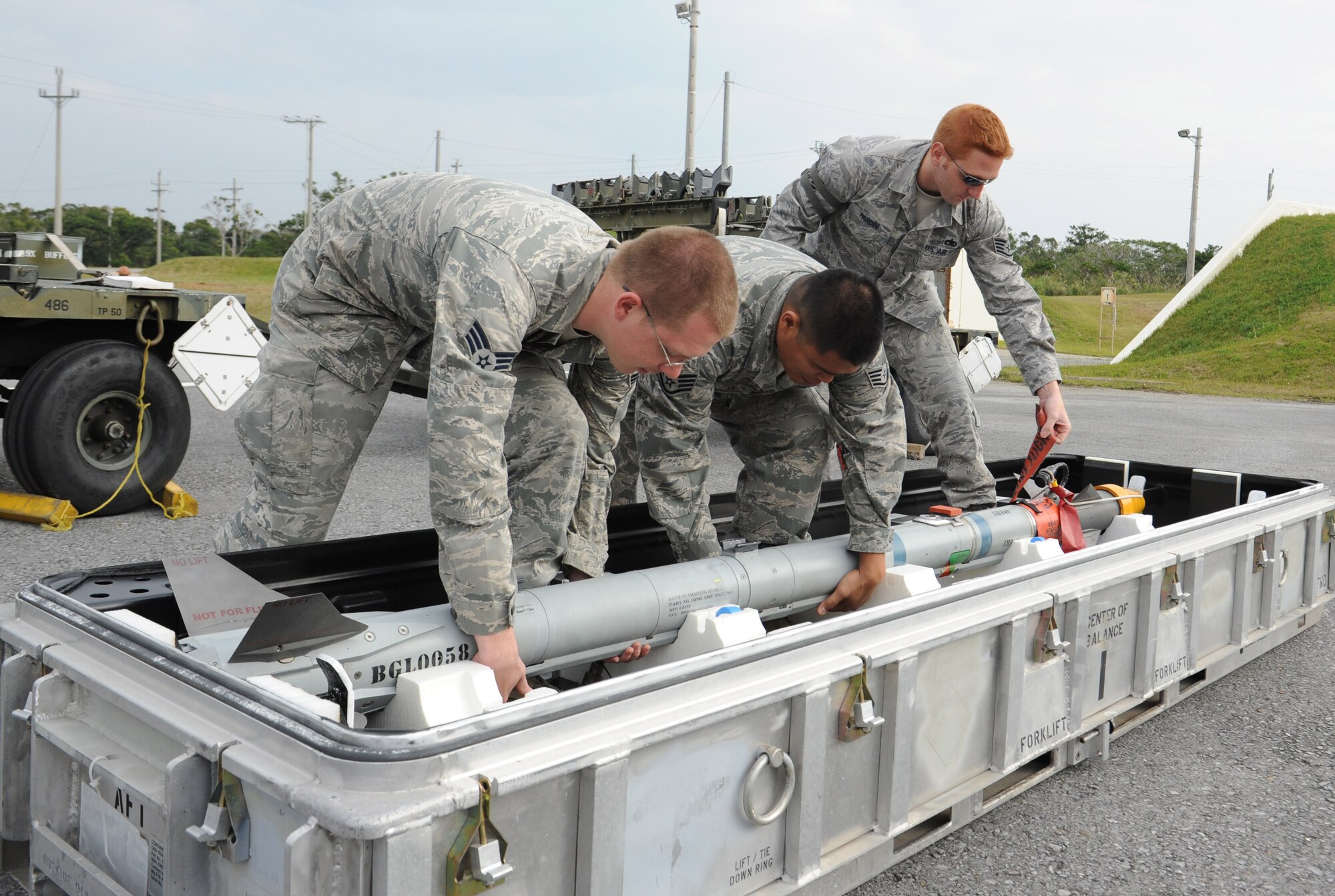 U.S. Air Force 18th Munitions Squadron Airmen prepare to lift a dummy air-to-air 9X training missile on Kadena Air Base, Japan, March 5, 2013. The Airmen were tested on their ability to build bombs in a simulated wartime scenario as part of a combat ammunition production exercise. (U.S. Air Force photo/Airman 1st Class Malia Jenkins) 