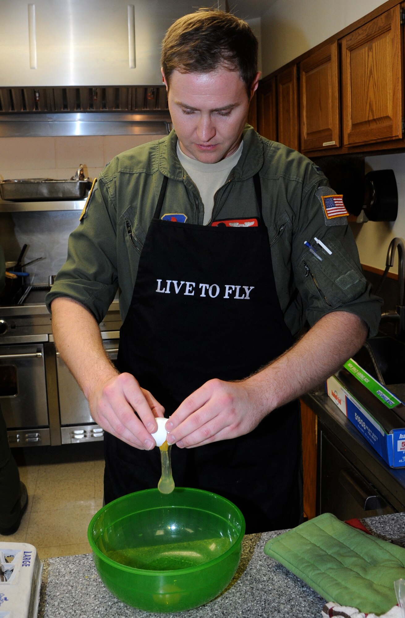First Lt. Mark West, an instructor pilot with the 8th Flying Training Squadron, prepares a breading mixture during the monthly Singles’ International Gourmet Meal Opportunity, March 4, at Vance Air Force Base, Okla. (U.S. Air Force photo/ Airman 1st Class Frank Casciotta)
