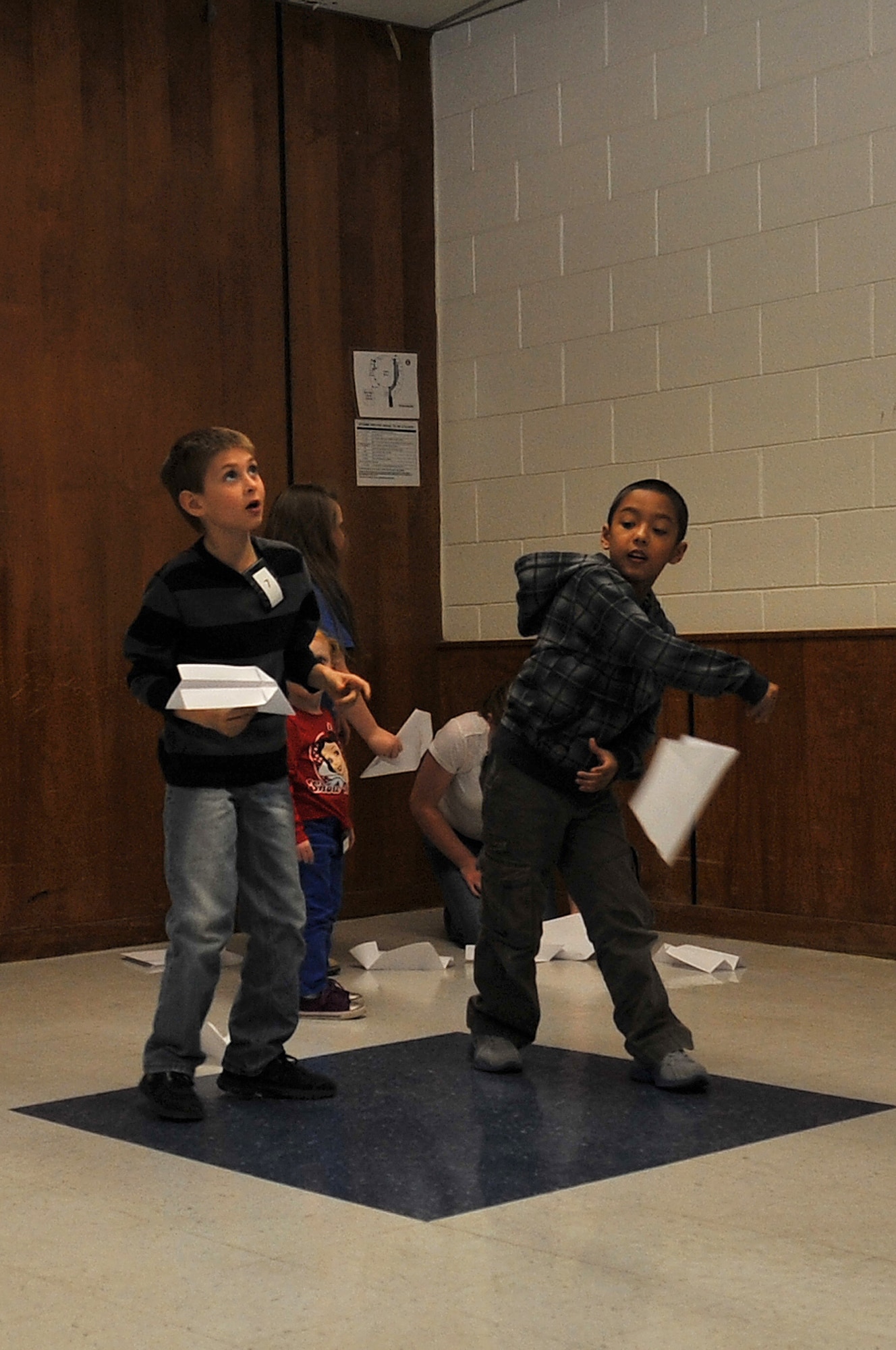 ALTUS, Okla. – Children from local Altus schools play with paper airplanes while their parents participate in the first Getting InvolvED education event at Altus High School March 5, 2013. The Altus High School Junior Reserve Officer Training Corps offered free child care for children of parents who were in attendance to help ensure that all parents would be able to participate. (U.S. Air Force photo by Senior Airman Dillon Davis/Released)