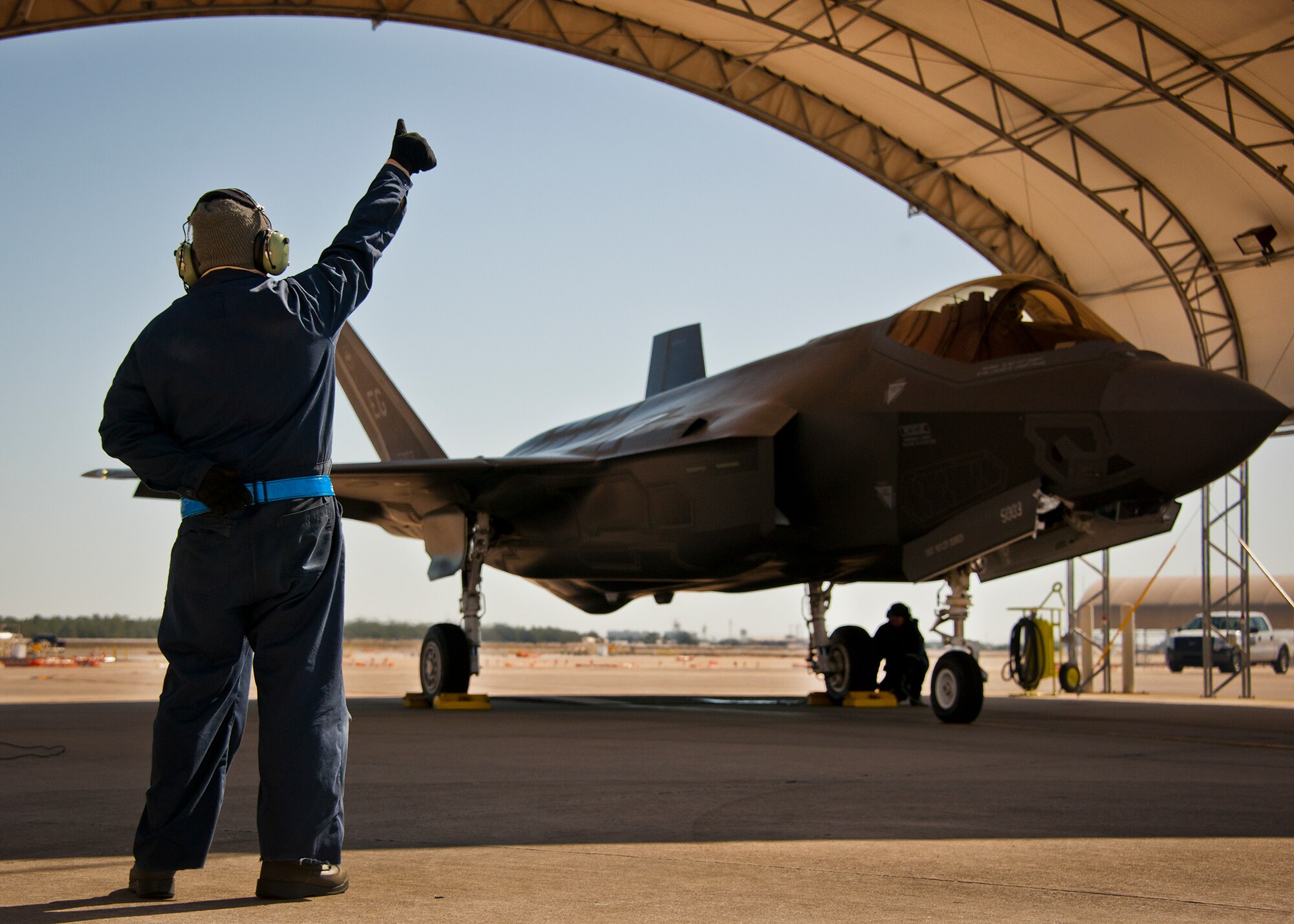 Airman 1st Class Lance Colbert, a crew chief with the 33rd Aircraft Maintenance Squadron gives a thumbs-up to the pilot and ground crew prior to marshalling out the F-35A Lightning II at Eglin Air Force Base, Fla., March 6. (U.S. Air Force photo/Samuel King Jr.)