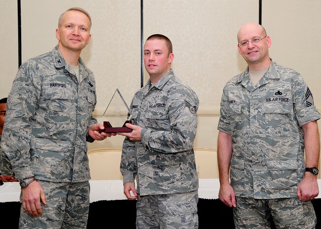 Colonel Darren Hartford, 437th Airlift Wing commander, and Chief Master Sgt. Gerard Komen, 437th Maintenance Operations Squadron superintendent, congratulate Senior Airman Joseph Shewmaker, 437th Operations Group knowledge operations manager, as a Diamond Sharp award winner during a ceremony March 5, 2013, at the Charleston Club at Joint Base Charleston - Air Base, S.C. Diamond Sharp awardees are Airmen chosen by their first sergeants for their excellent performance. (U.S. Air Force photo/ Staff Sgt. Rasheen Douglas)
