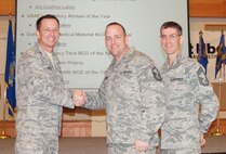 MSgt Small (center) is congratulated by medical group commander Colonel R. Bruce Roehm and mdical group superintendent CMSgt Duane Buchi during Medical Group Commander Call.