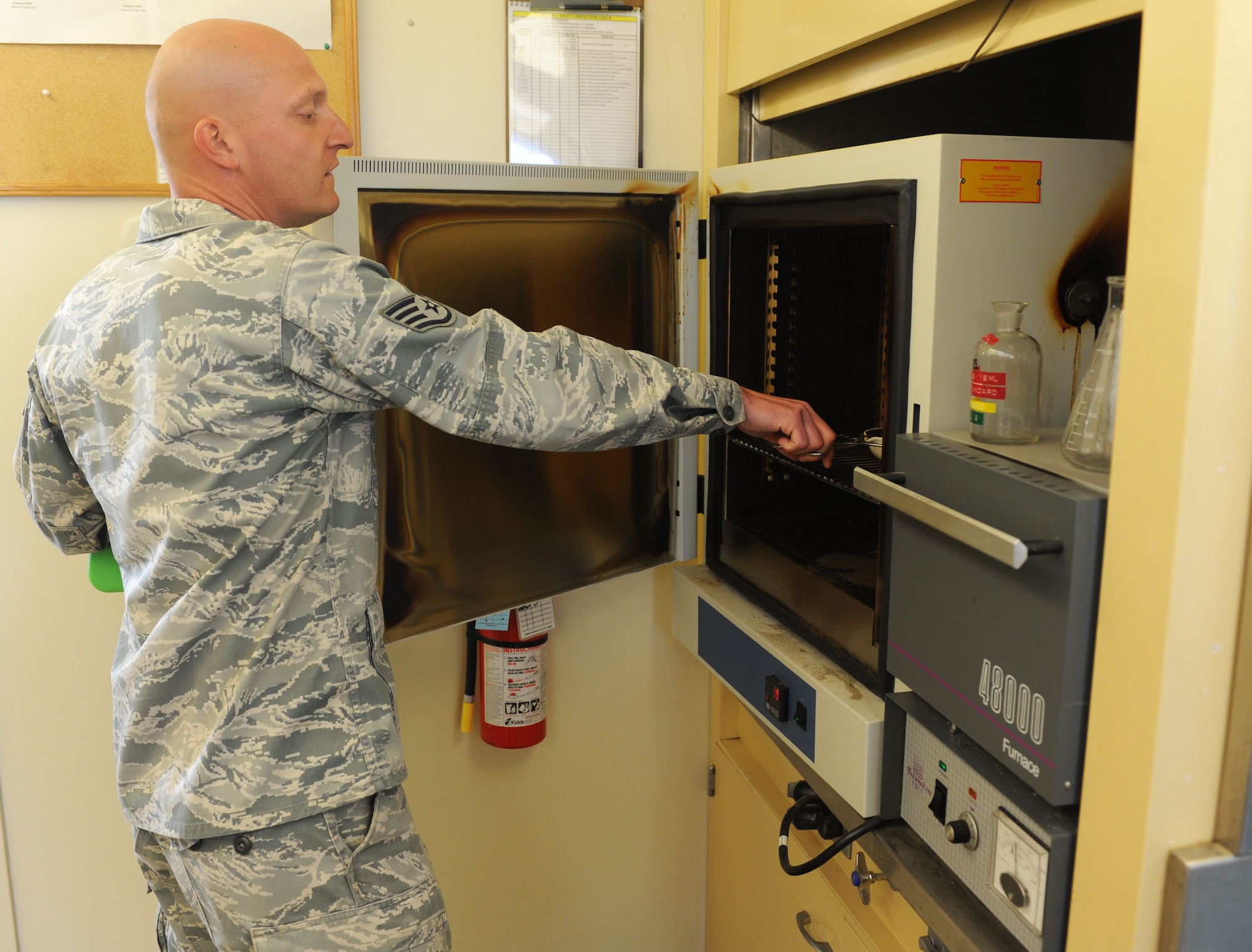 Staff Sgt. Paul Bauer, 9th Civil Engineer Squadron water and fuels system maintenance journeyman, prepares to bake a sample of bio-solid in an oven set to 265 degrees Celsius at the waste water facility on Beale Air Force Base, Calif., March 5, 2013. Through this scientific process the facility is able to determine how much bacteria is being removed from the bio-solid. (U.S. Air Force photo by Airman 1st Class Bobby Cummings/Released)