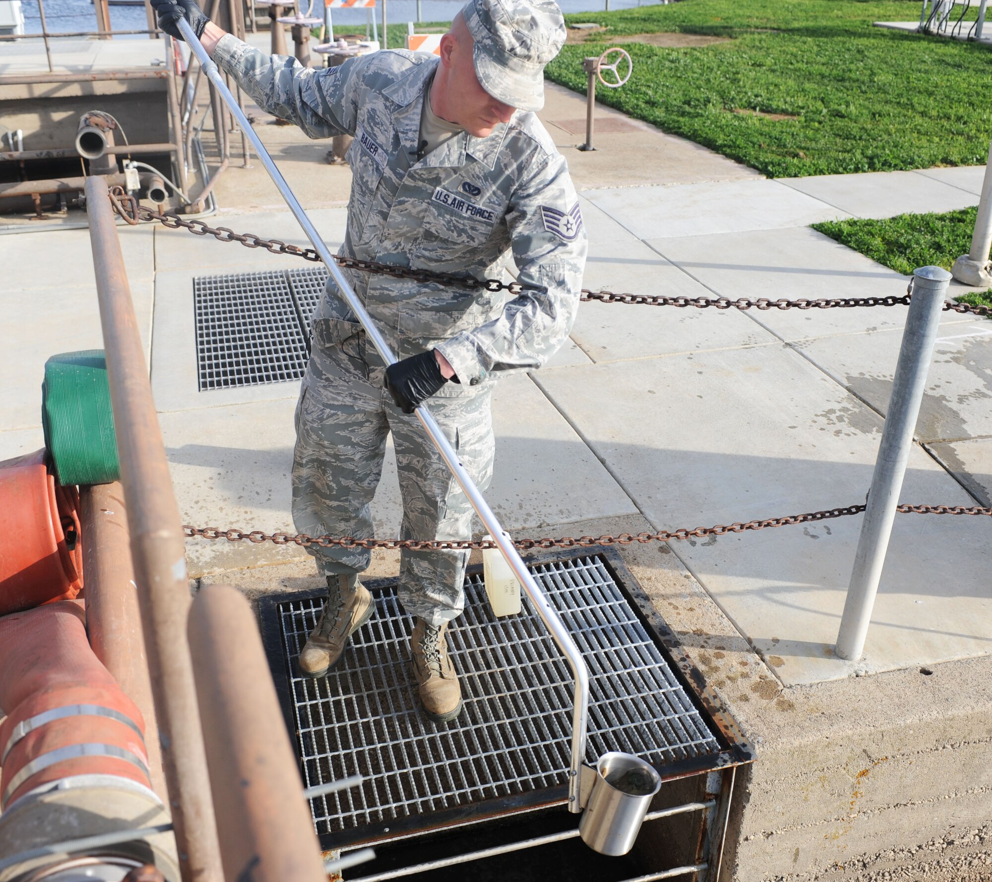 Staff Sgt. Paul Bauer, 9th Civil Engineer Squadron water and fuels system maintenance journeyman, collects a sample of bio-solids from the primary clarifier at the waste water facility on Beale Air Force Base, Calif., March 5, 2013. The facility safely treats the waste water on Beale and provides clean drinking water. (U.S. Air Force photo by Airman 1st Class Bobby Cummings/Released)