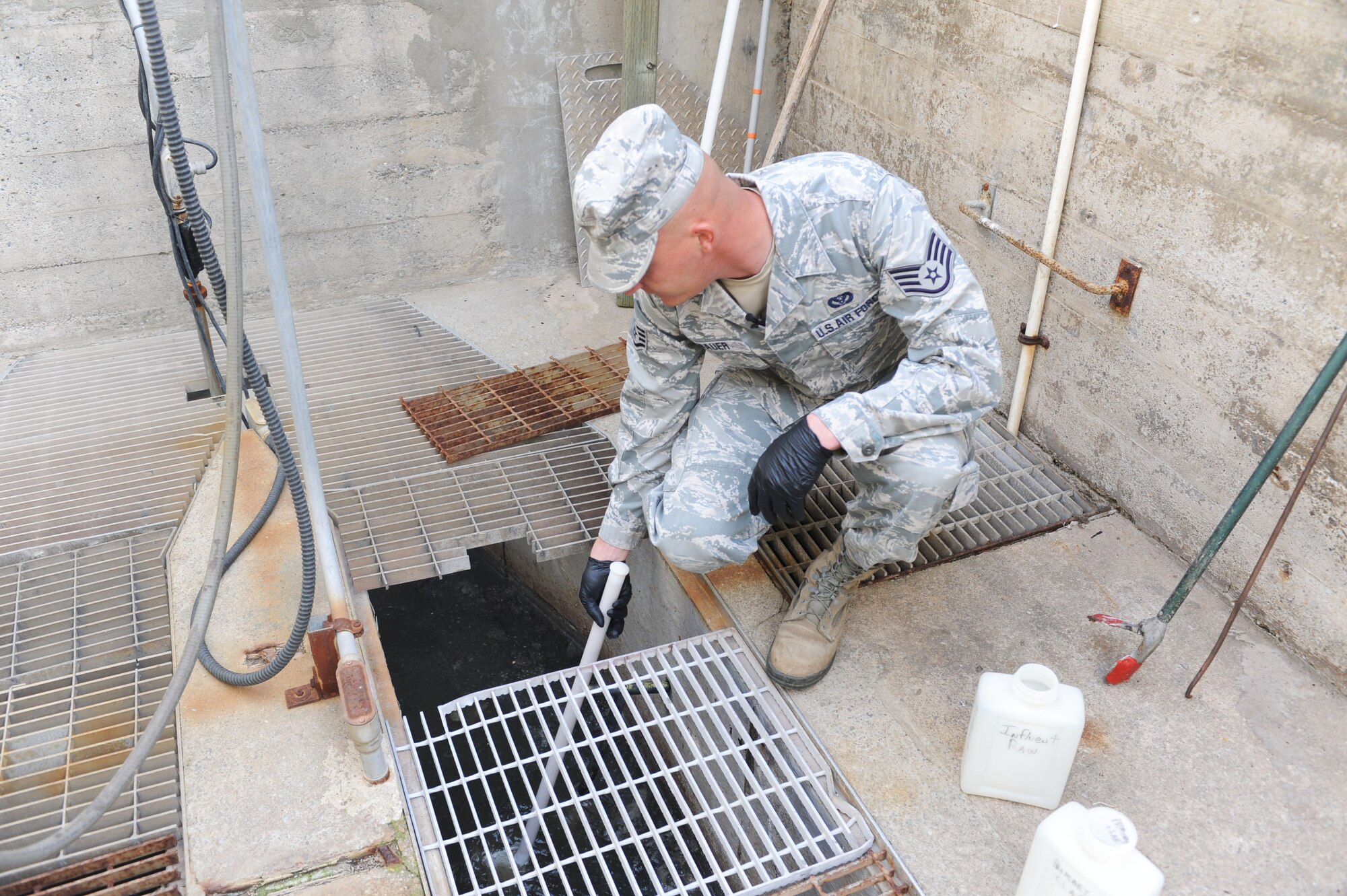 Staff Sgt. Paul Bauer, 9th Civil Engineer Squadron water and fuels system maintenance journeyman, collects a sample of bio-solids at the waste water facility on Beale Air Force Base, Calif., March 5, 2013. The facility safely treats waste water on Beale and provides clean drinking water. (U.S. Air Force photo by Airman 1st Class Bobby Cummings/Released)