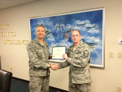 Colonel Darren Hartford, 437th Airlift Wing commander, presents Master Sgt. Gregory Butler, 437th Aircraft Maintenance Squadron Air Force Special Operations of the 21st Century program manager, the AFSO21 Century Green Belt Qualification certificate March 5, 2013 at Joint Base Charleston – Air Base, S.C.  AFSO21 focuses on generating efficiencies and improving combat capability across the Air Force. (Courtesy photo)