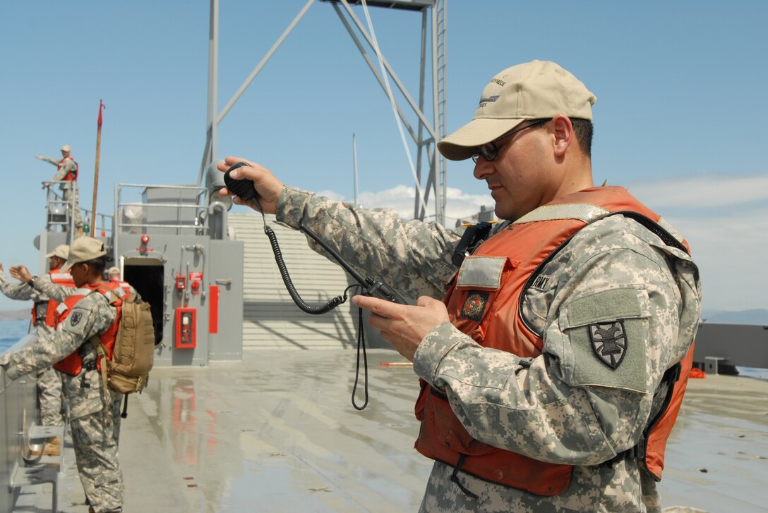During a man-overboard drill, crew members point towards the location of the soldier, played by a dummy, who fell overboard. All available crew members point towards the man overboard as it is easy to lose sight of a person in open waters. (U.S. Army photo by Sgt. Barbara J. Liau, 123rd Mobile Public Affairs Detachment)