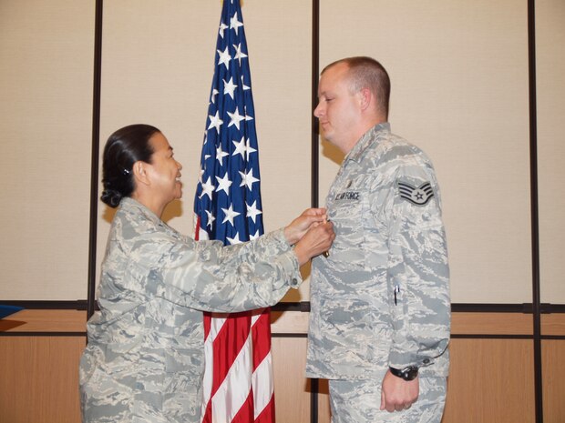 SSgt Bloomfield receives medal from his commander, Lt Col Editha Heberlein