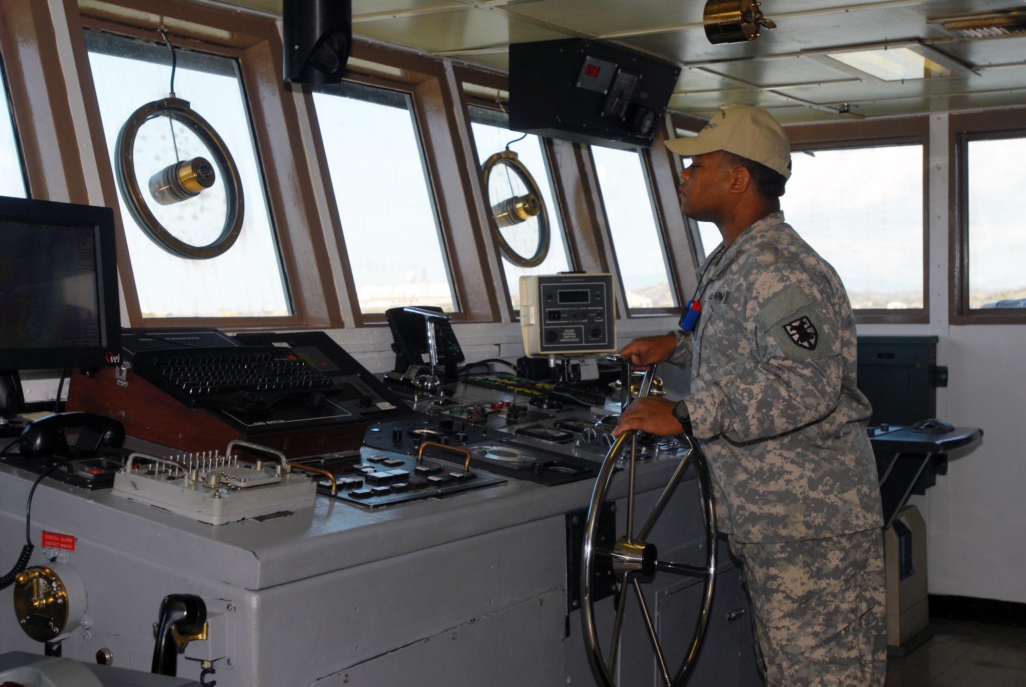 A crew member steers the LCU 2001 "Runnymede" out of Guantanamo Bay and into open waters. The LCU 2000 watercraft series is used to transport equipment from country to country and is essential to many humanitarian-related missions. (U.S. Army photo by Sgt. Barbara J. Liau, 123rd Mobile Public Affairs Detachment)
