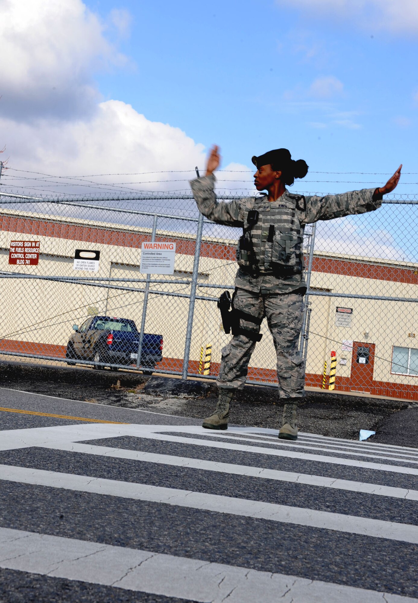 U.S. Air Force Staff Sgt. Latonya King, 633rd Security Forces Squadron patrolman, directs traffic during a fuel spill exercise at Langley Air Force Base, Va., Feb. 28, 2013. In this exercise, security forces create barriers so vehicles do not drive into the contaminated area. (U.S. Air Force photo by Senior Airman Brittany Paerschke-O’Brien/ Released)