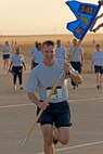 CMSgt Buchi crosses the finish line with the 341st Medical Group guidon during a medical group sponsored fitness event.