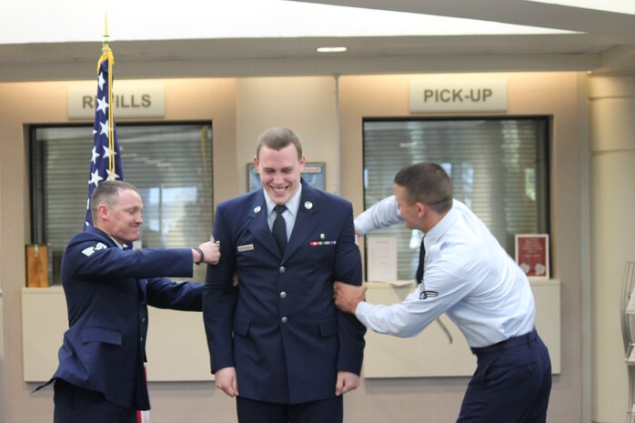 SSgt Delperdang gets a little help ensuring his stripes stay put from his friends.