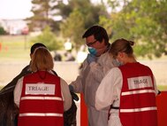 Mr Fallon receives a patient from the In-Place Patient Decontamination tent for further processing and treatment. .