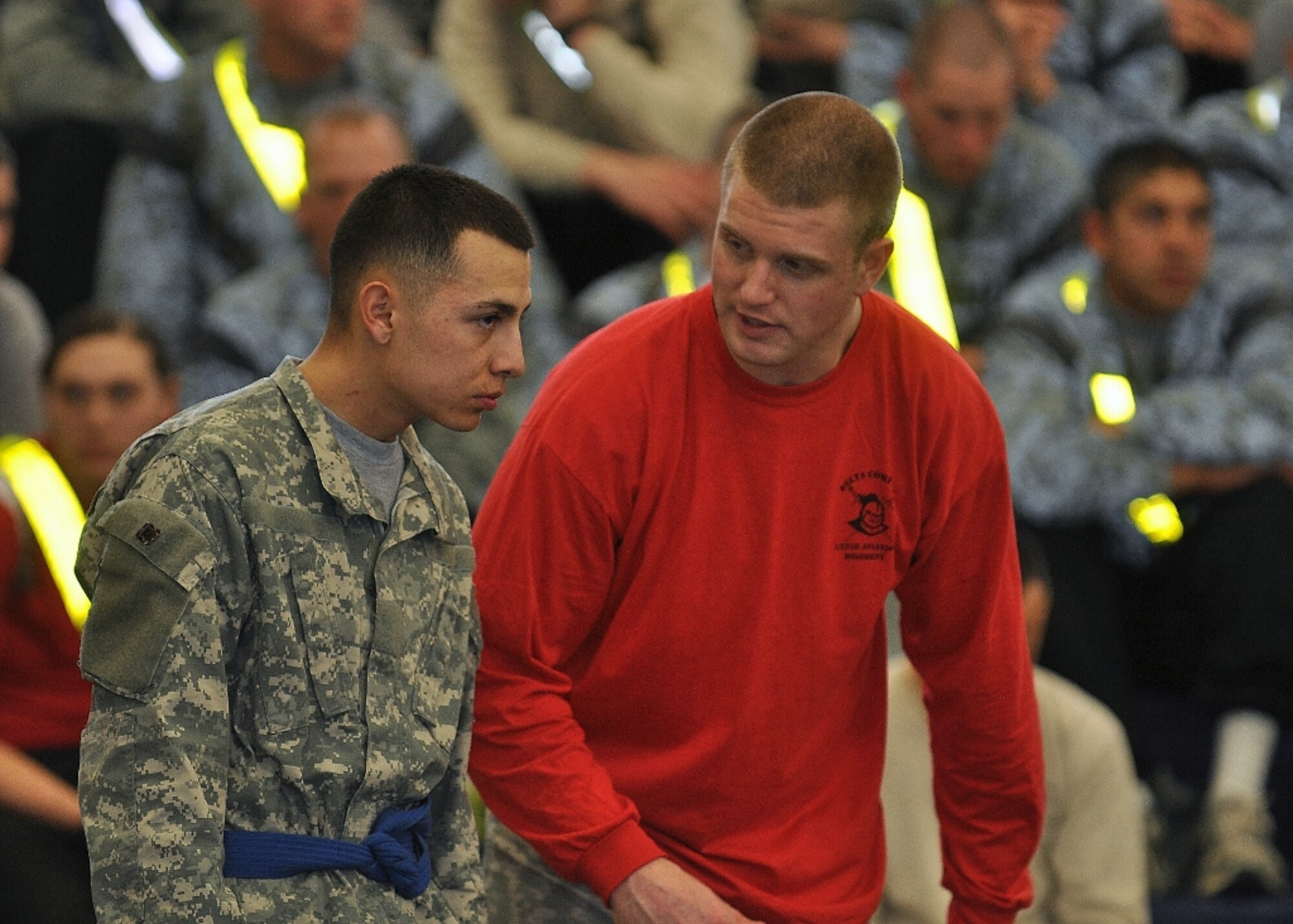 U.S. Army Pfc. Isaac Trujillio, assigned to D Company, listens to a trainer before a match during the 1st Battalion, 222nd Aviation Regiment's biannual combatives tournament at Anderson Field House at Fort Eustis, Va., Feb. 23, 2013. D Co. took top honors at the event, scoring 33 points from their competitor's matches. (U.S. Air Force photo by Senior Airman Jason J. Brown/Released)